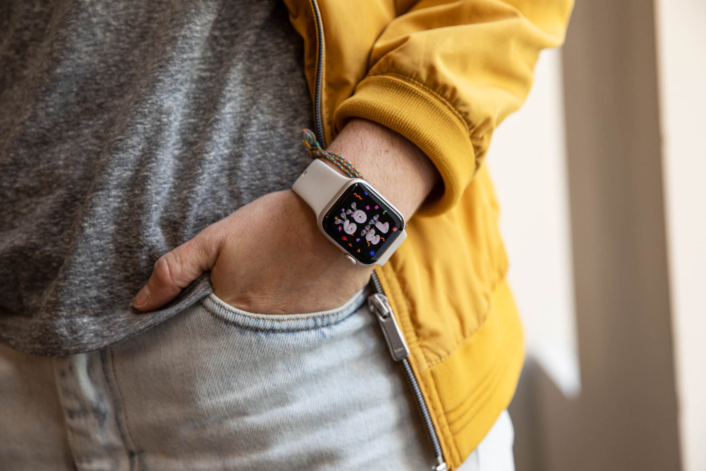 رجل يرتدي سترة صفراء طرازات Apple Watch SE (2022)