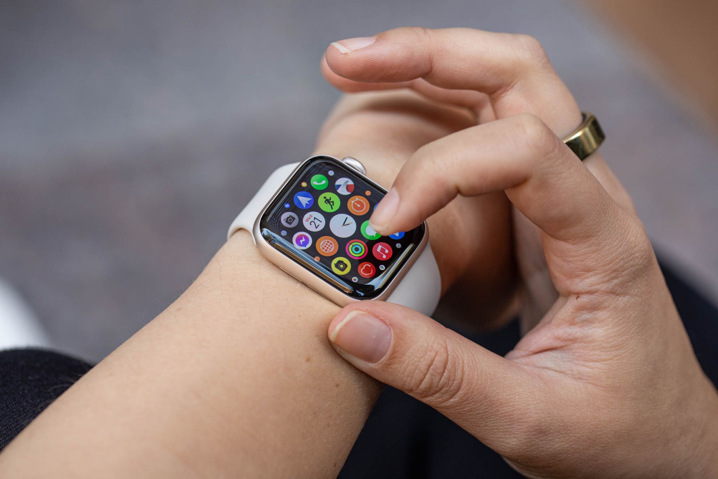 امرأة تنظر إلى شبكة التطبيقات على Apple Watch SE (2022).