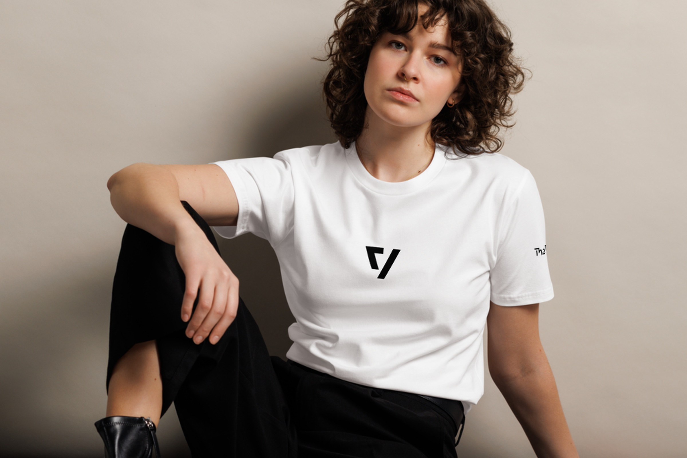 Woman sitting down wearing The Verge white t-shirt