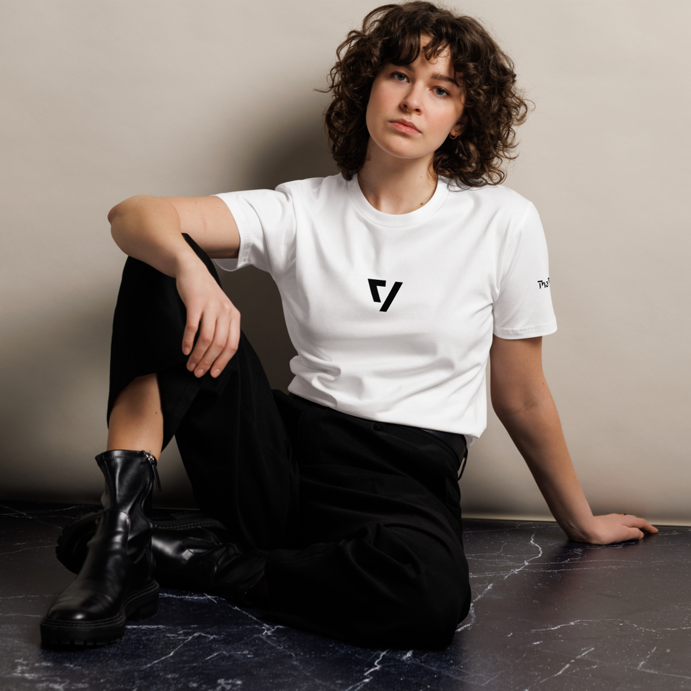 Woman sitting down wearing The Verge white t-shirt