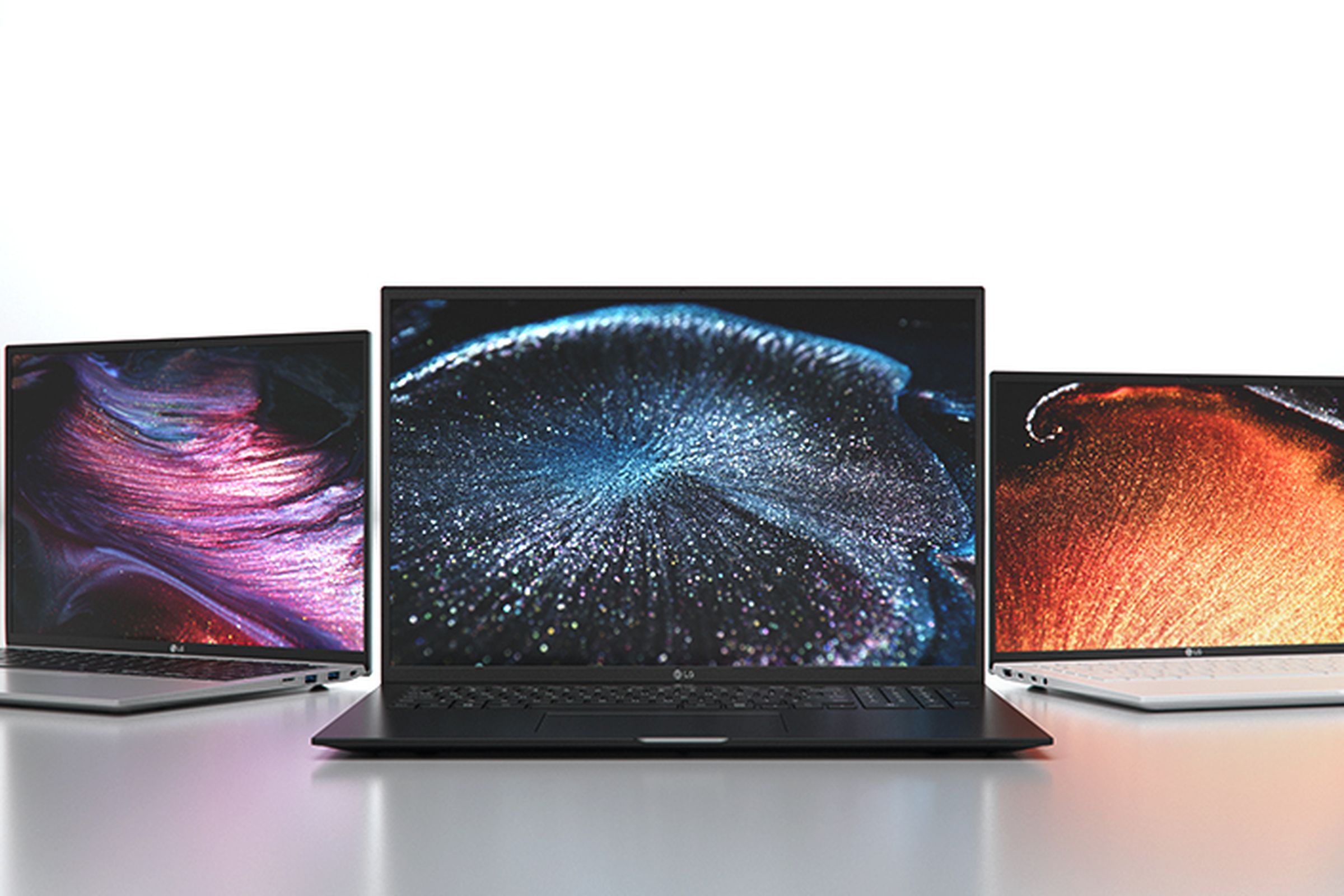 Three LG Gram laptops open, facing the camera in a convex semicircle. Each screen displays a space image.