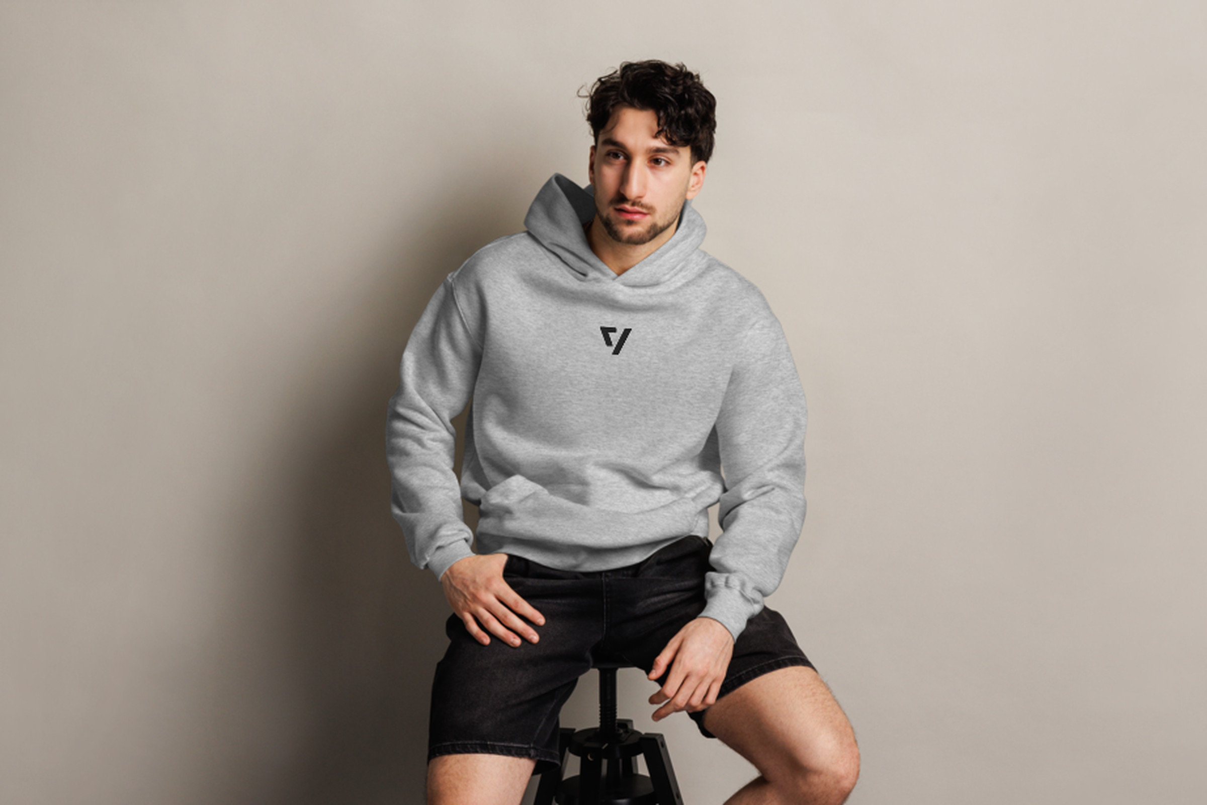 Man sitting on stool wearing The Verge greyscale hoodie