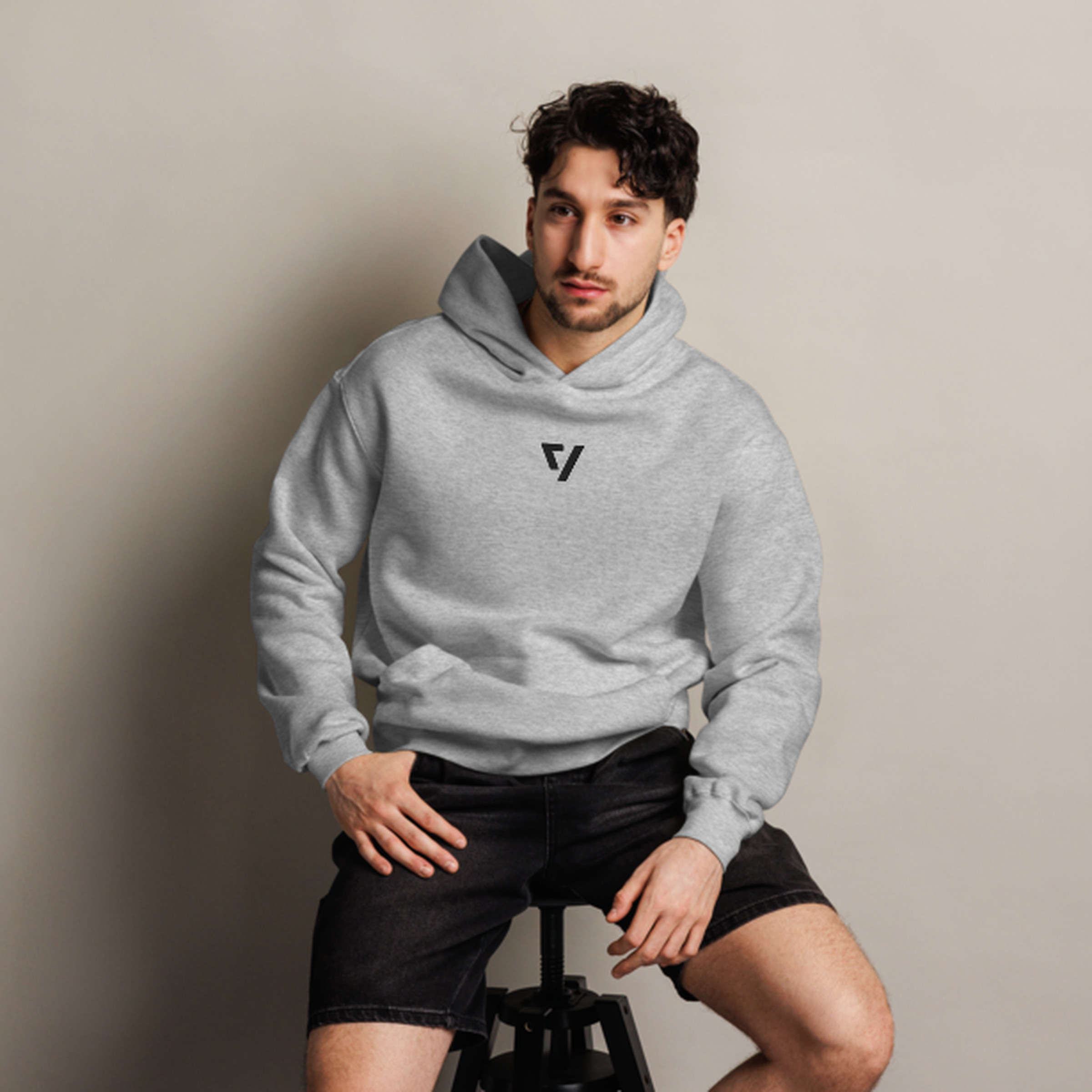 Man sitting on stool wearing The Verge greyscale hoodie