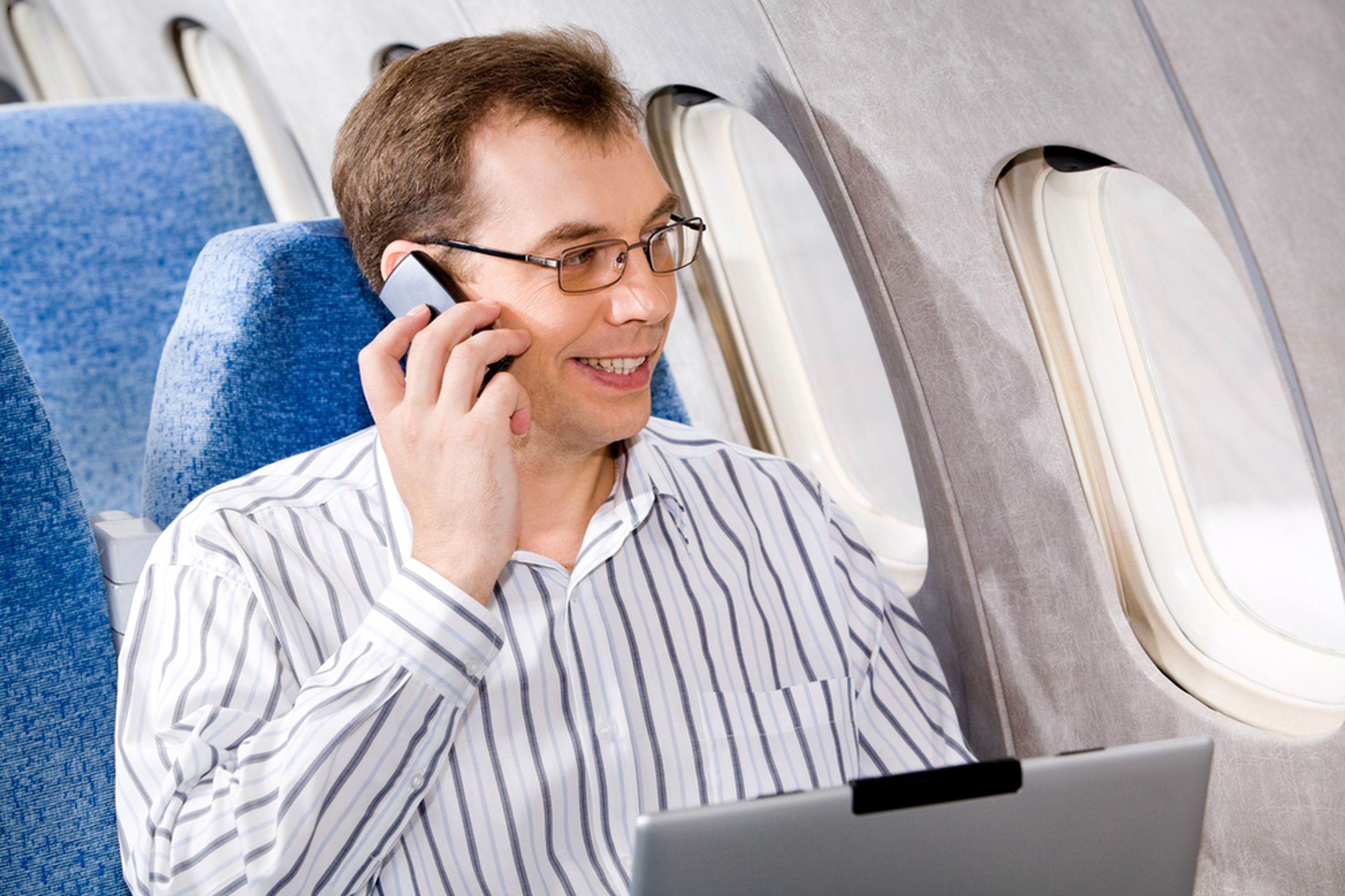 Man on cellphone in plane http://www.shutterstock.com/pic-6689698/stock-photo-portrait-of-business-man-calling-by-phone-in-the-airplane.html