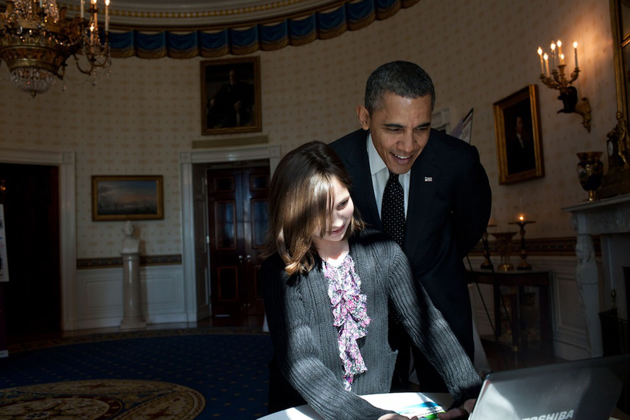 President Obama looks over shoulder at laptop (Credit: Pete Souza/The White House Flickr) 
