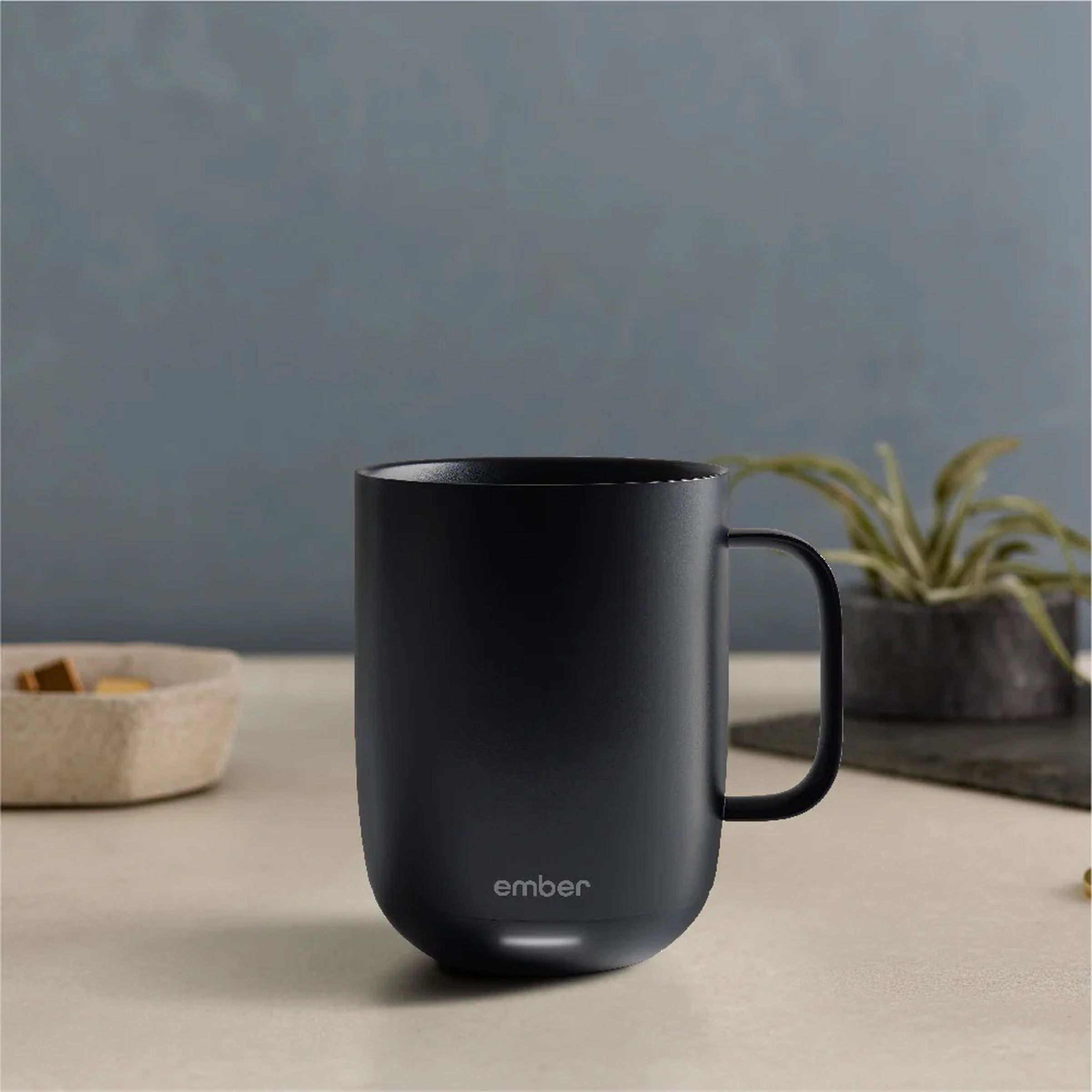 A photo of a black smart mug on a wooden table.
