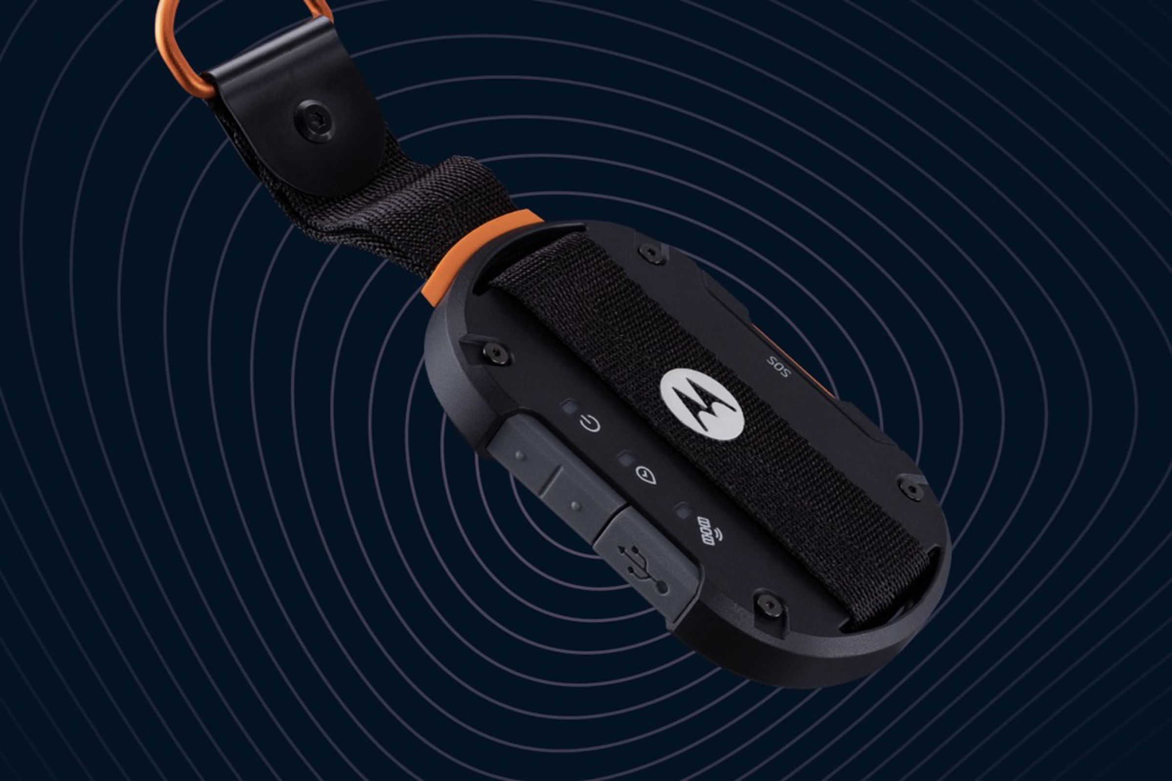 The defy satellite link looks like a car key fob on a keychain with an orange key loop. It’s got a M logo in the middle, waterproof covered USB port, and buttons on the side.