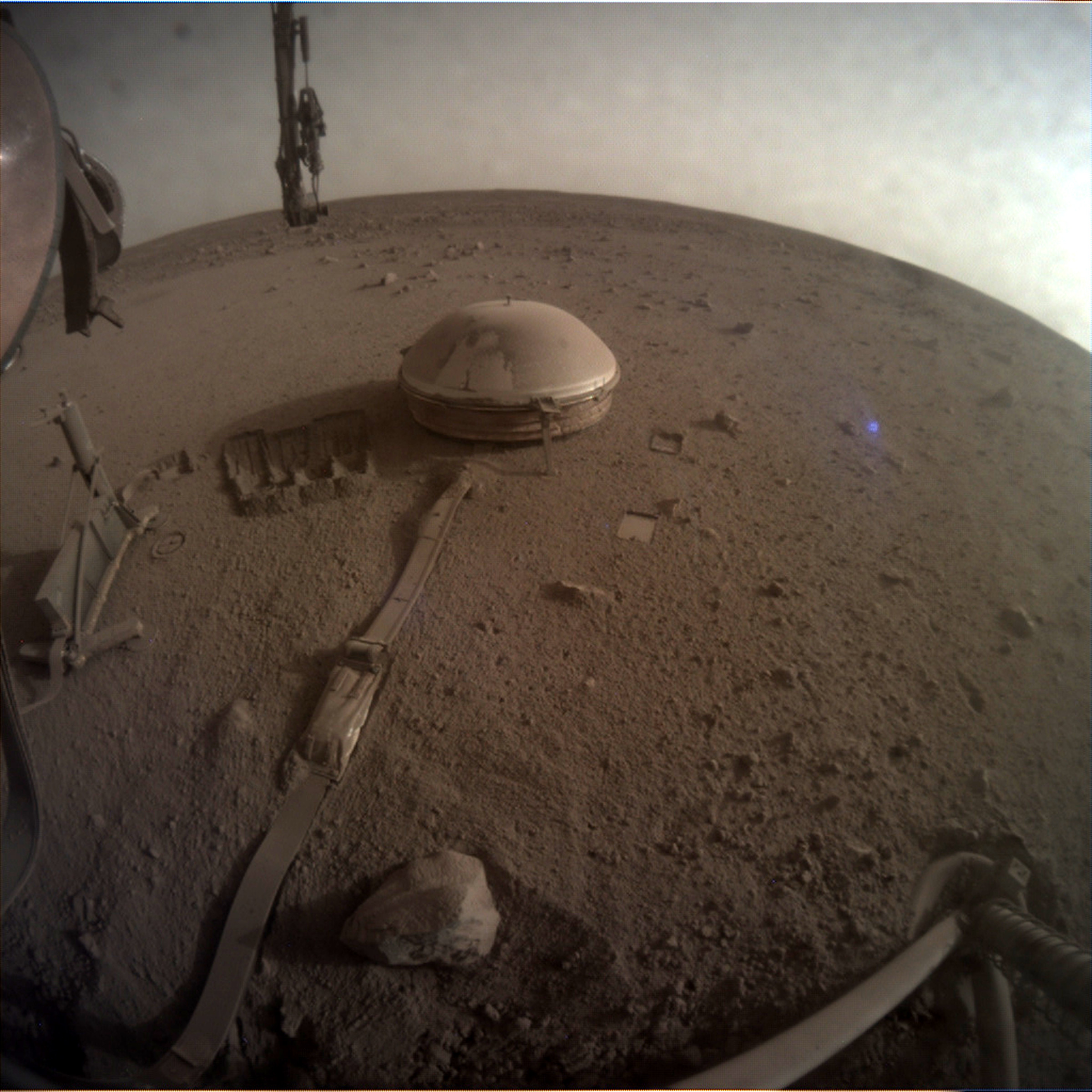 An image of dust-covered equipment sitting on a desolate Martian plain.