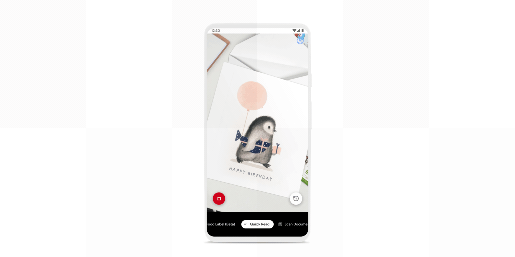 Smartphone is shown in quick read mode, reading “Happy Birthday” from a card with a penguin on it.