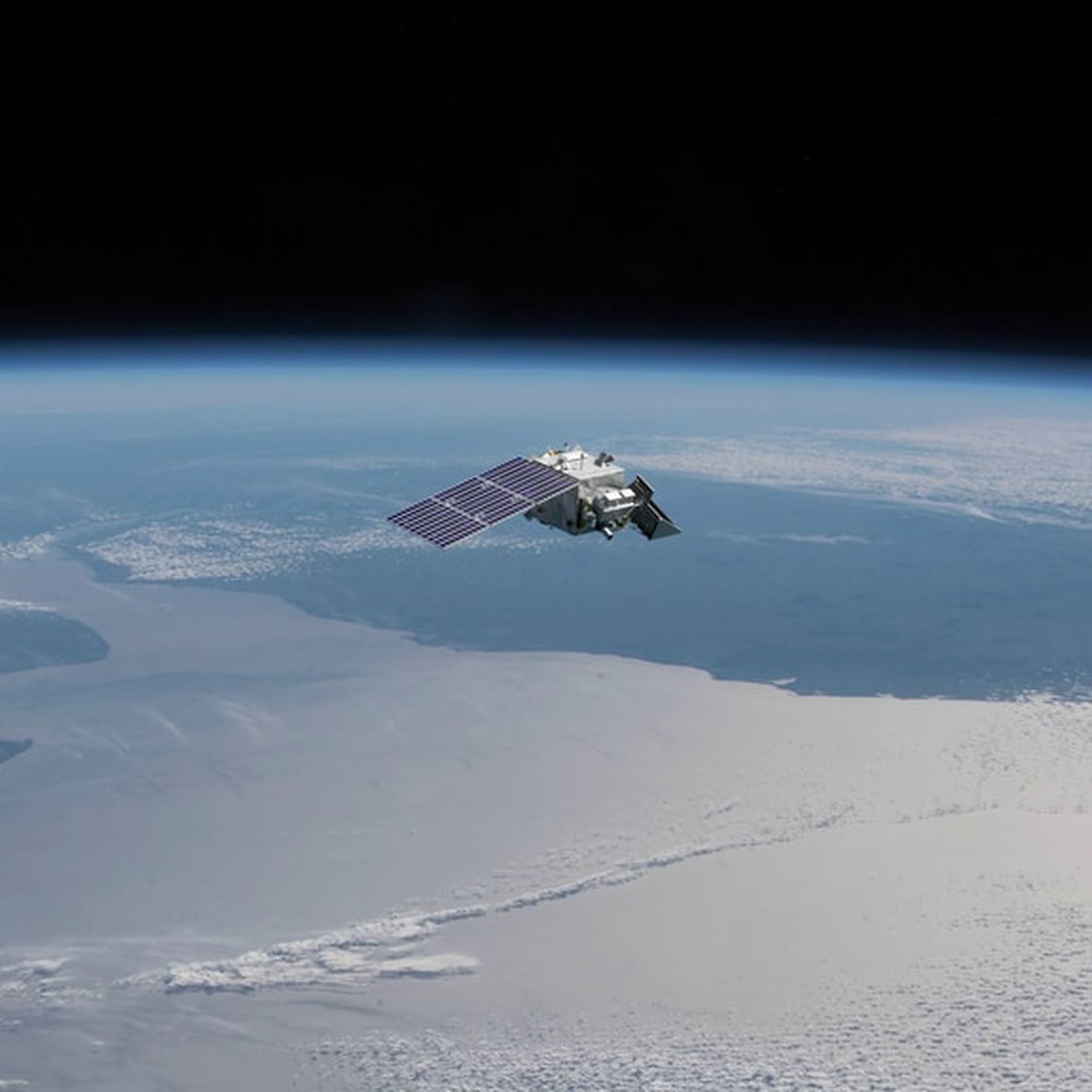A rendering of a satellite seen above clouds, sea, and land masses.