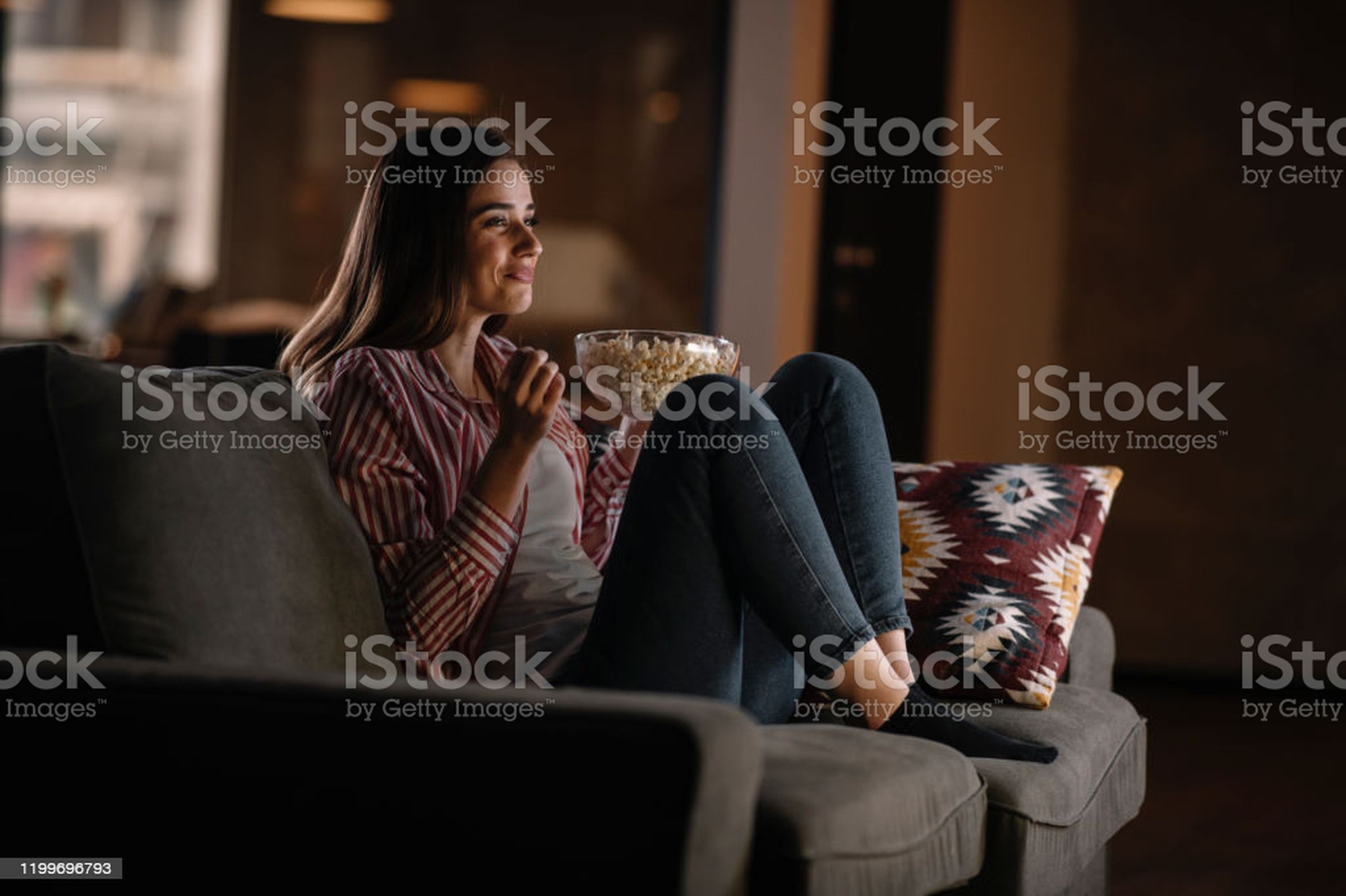 “Girl on the sofa in the living room eating popcorn”