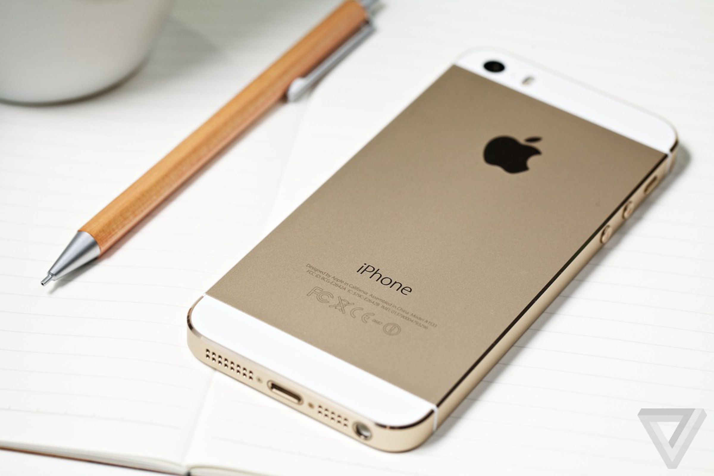 Image of a gold iPhone 5s laying on a table.