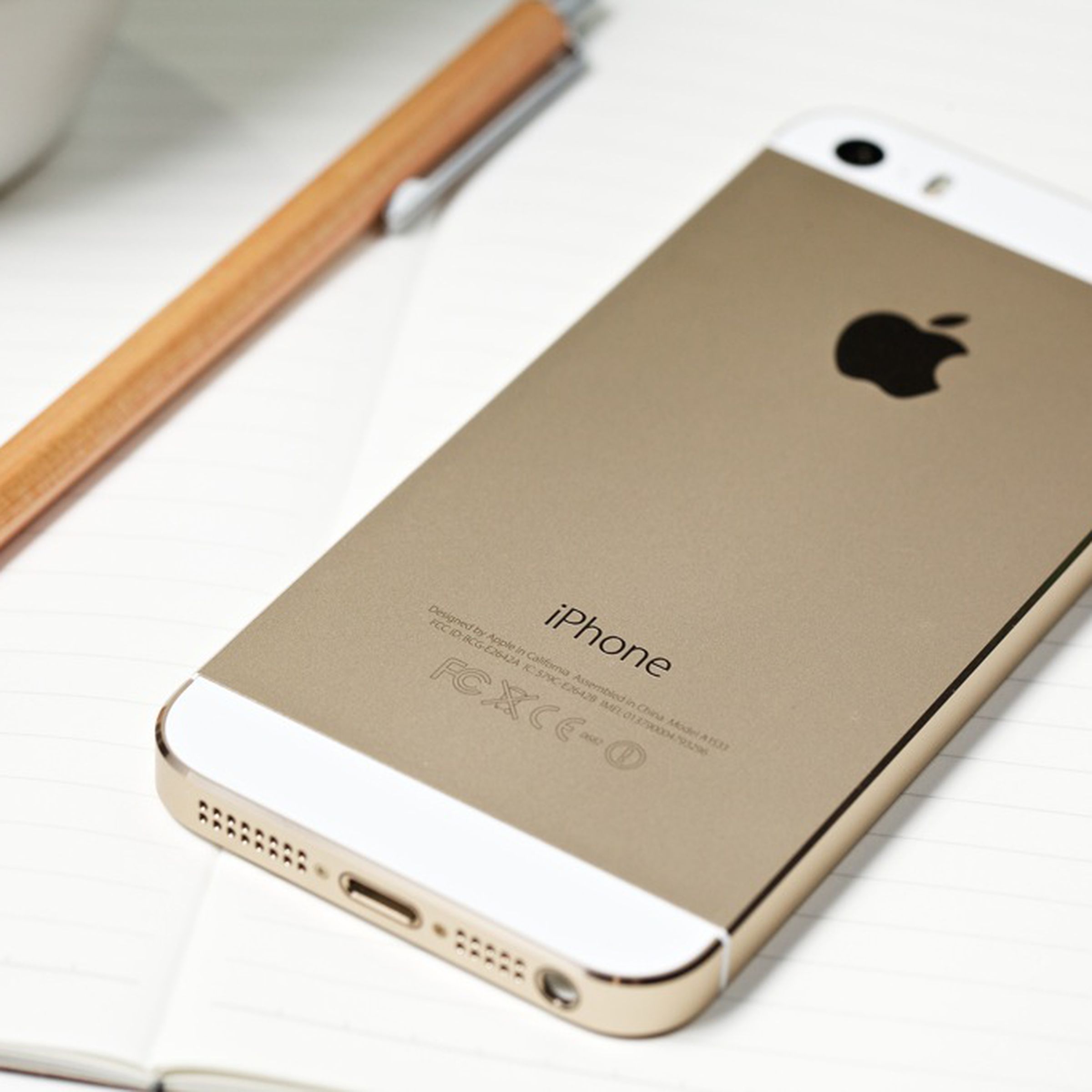 Image of a gold iPhone 5s laying on a table.