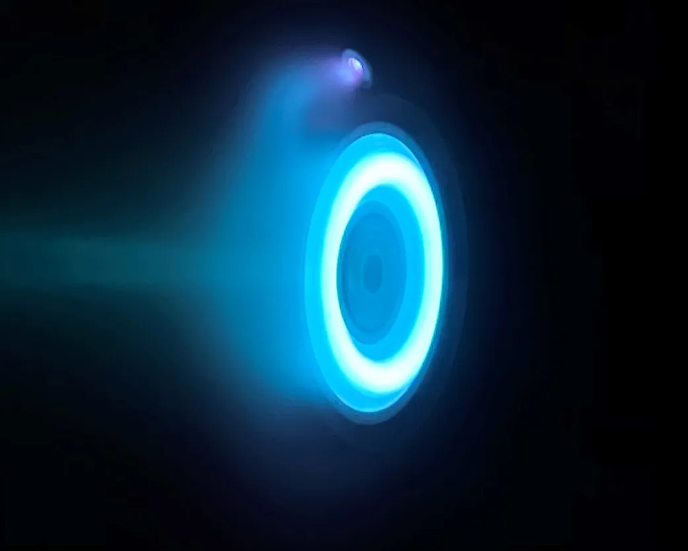The glowing blue ring of an electric Hall thruster. in an otherwise black image.