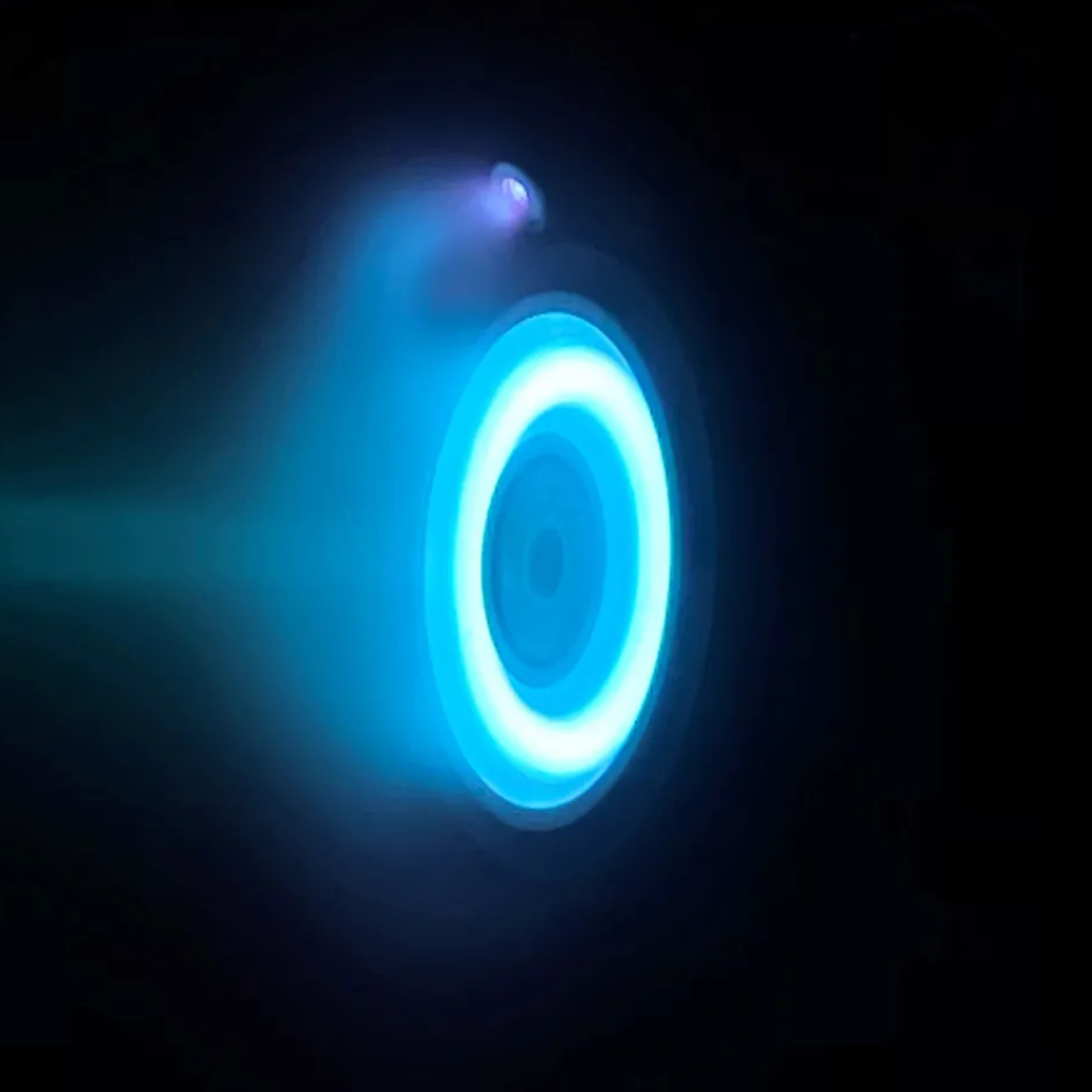 The glowing blue ring of an electric Hall thruster. in an otherwise black image.