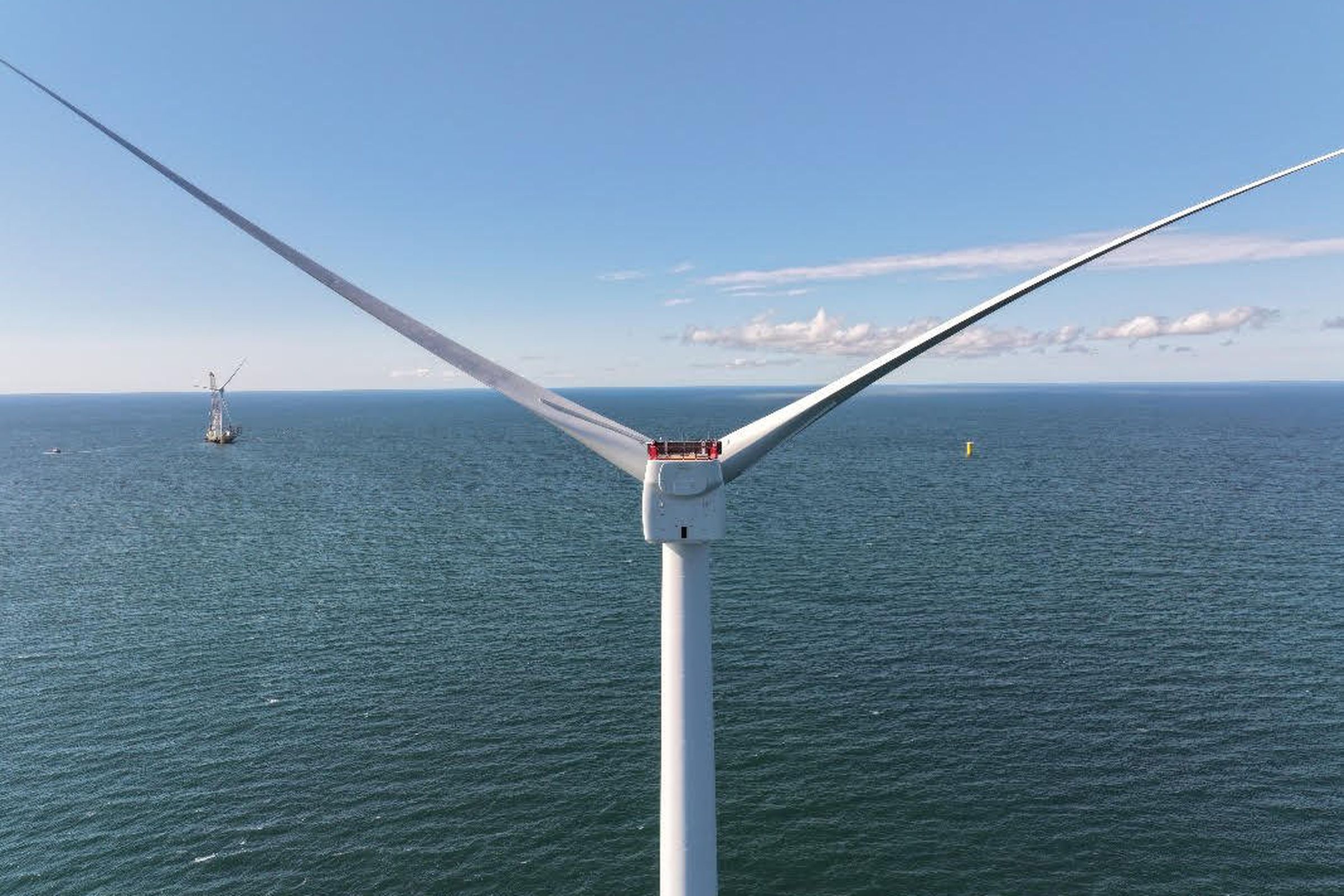 A close-up view of a wind turbine standing in the sea.
