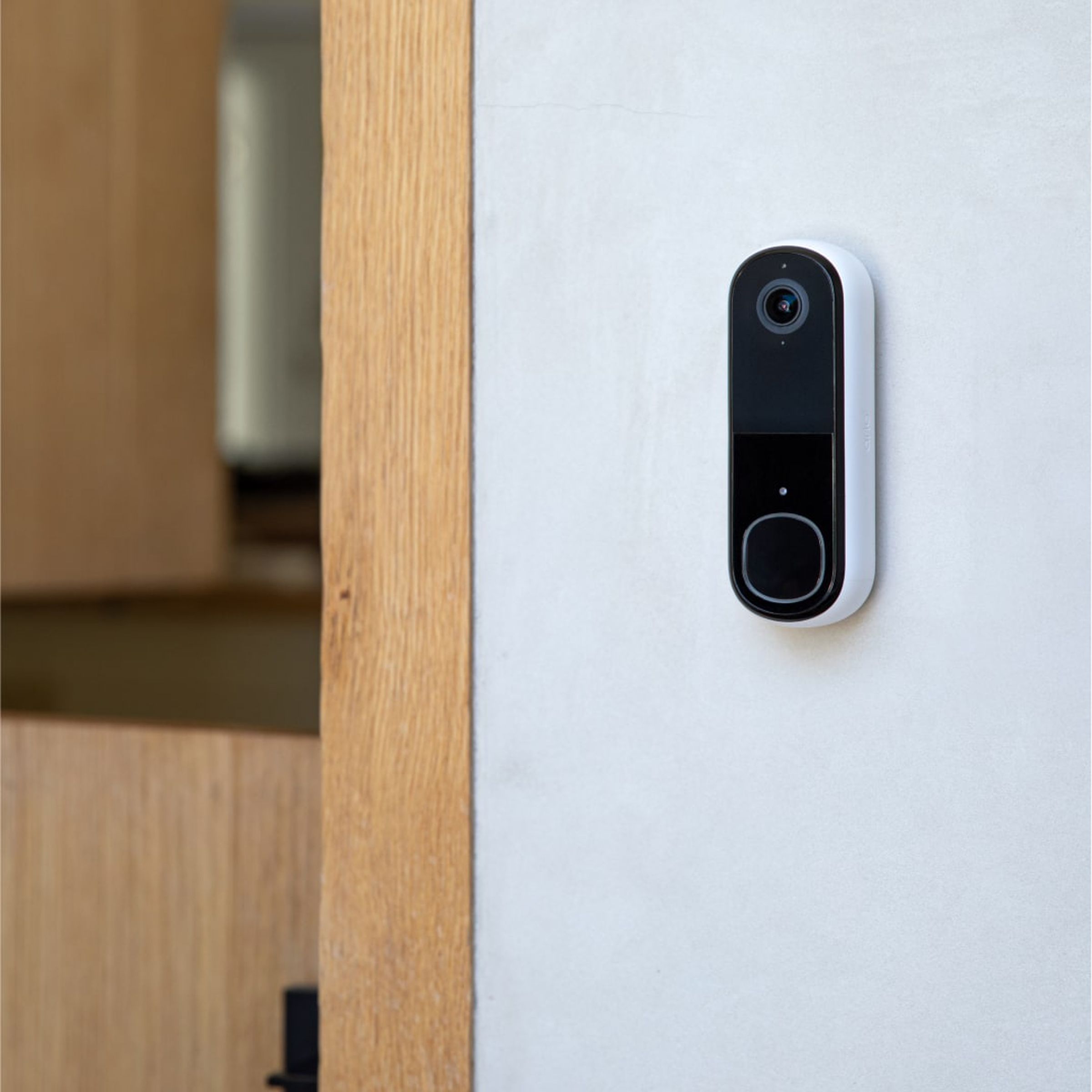 The Arlo Essential Doorbell second-gen on a door frame.