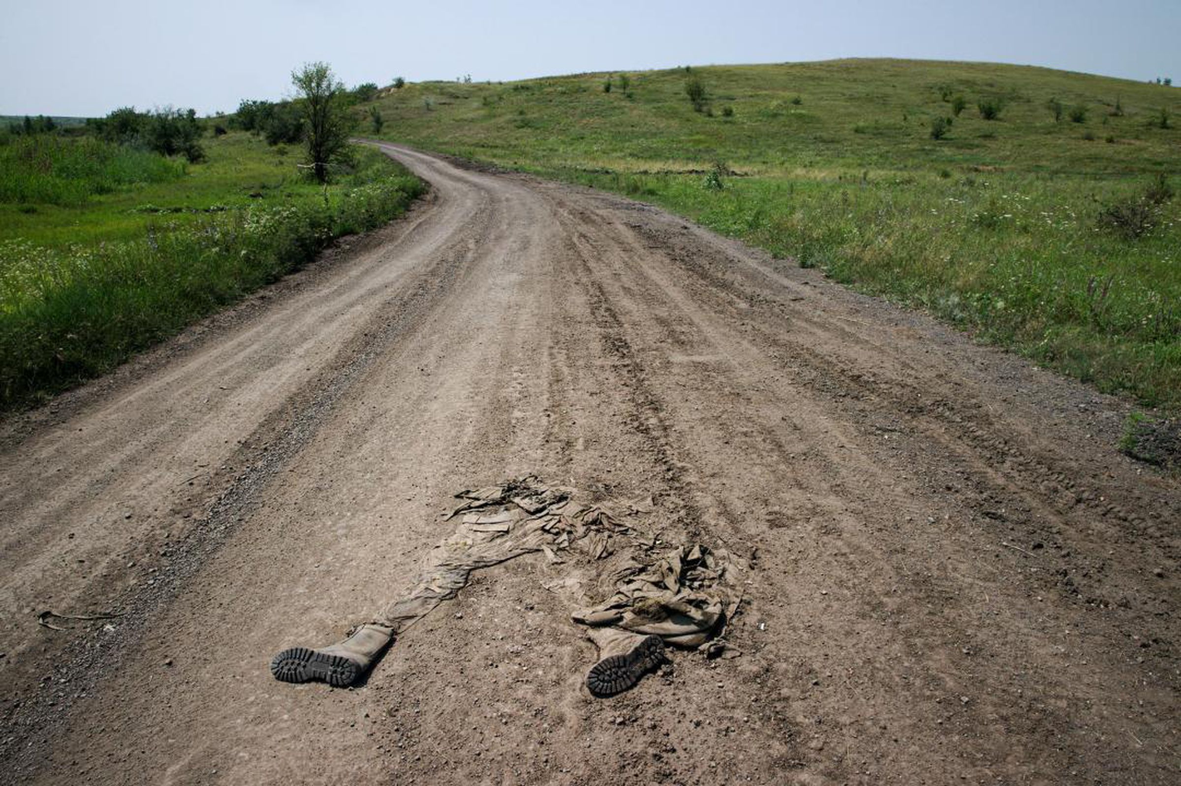 Tattered clothing of a Russian soldier in a Ukrainian road.