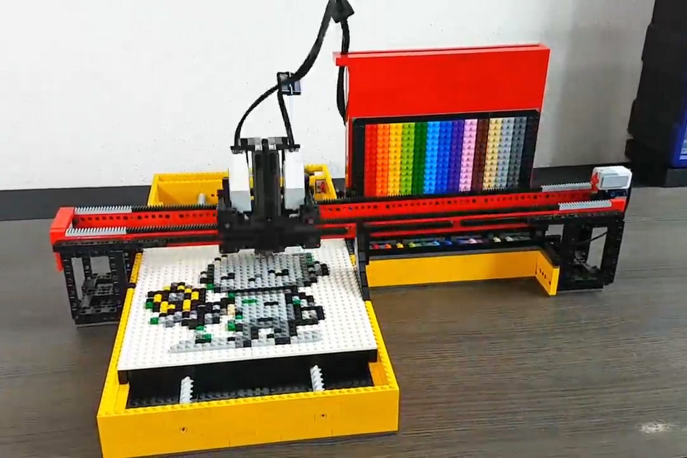 A plotter made from Lego is assembling pixel art.