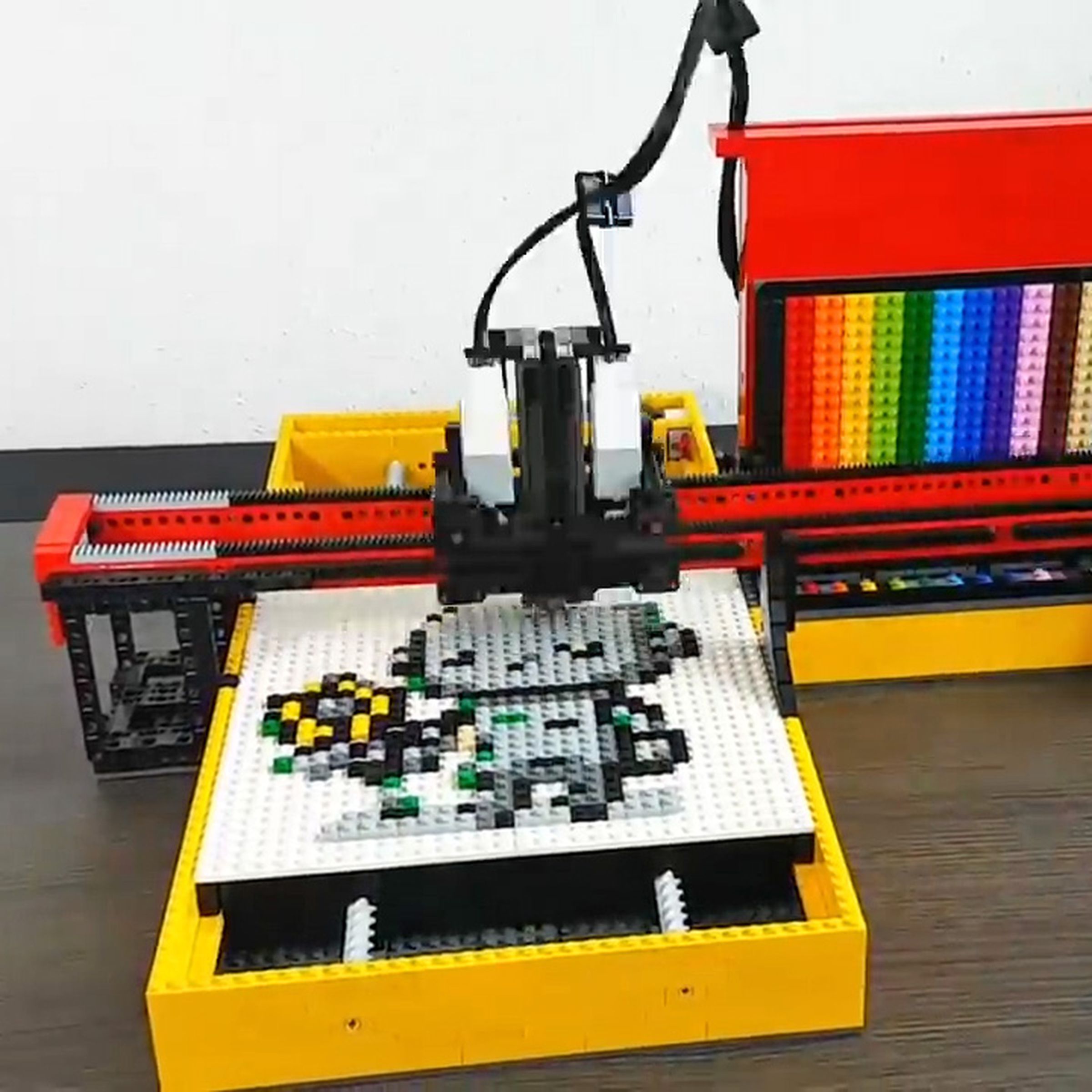 A plotter made from Lego is assembling pixel art.