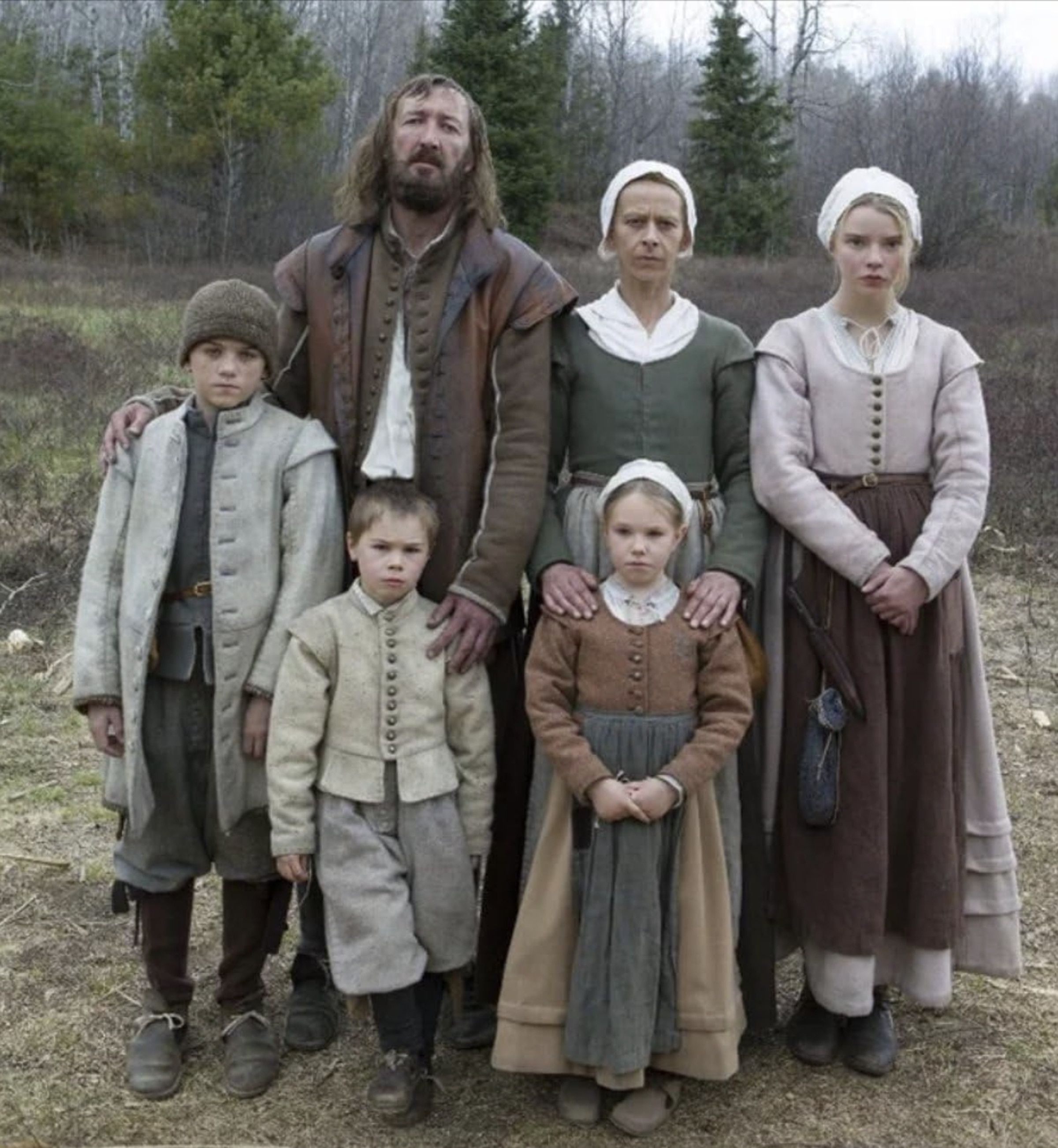 Screenshot from the 2015 film The Witch featuring a family of six Puritans.