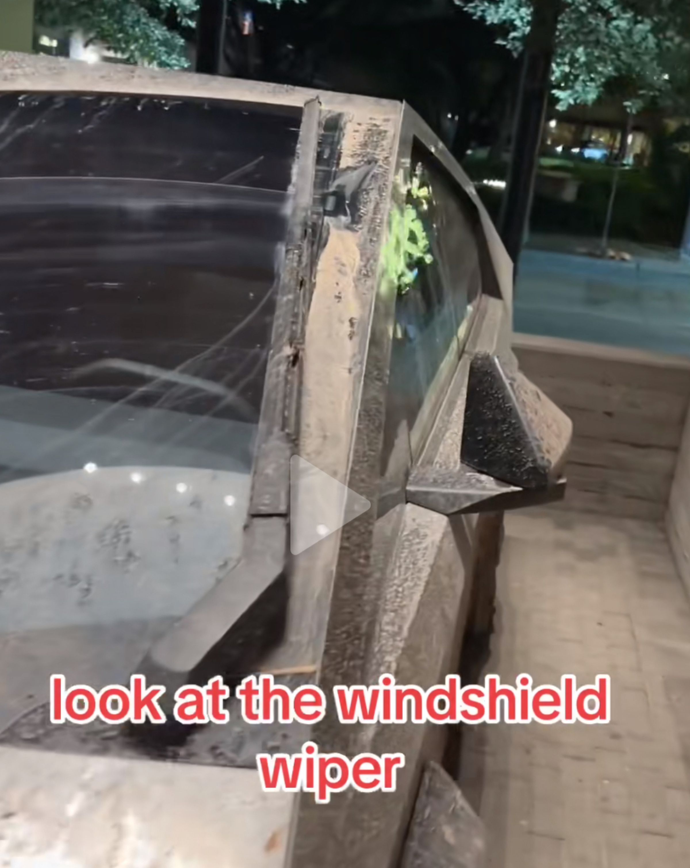 Close up photos of the Tesla Cybertruck windshield wiper on a very muddy truck, showing a line of mud on the windshield that may be evidence of the wiper being two wiper blades.