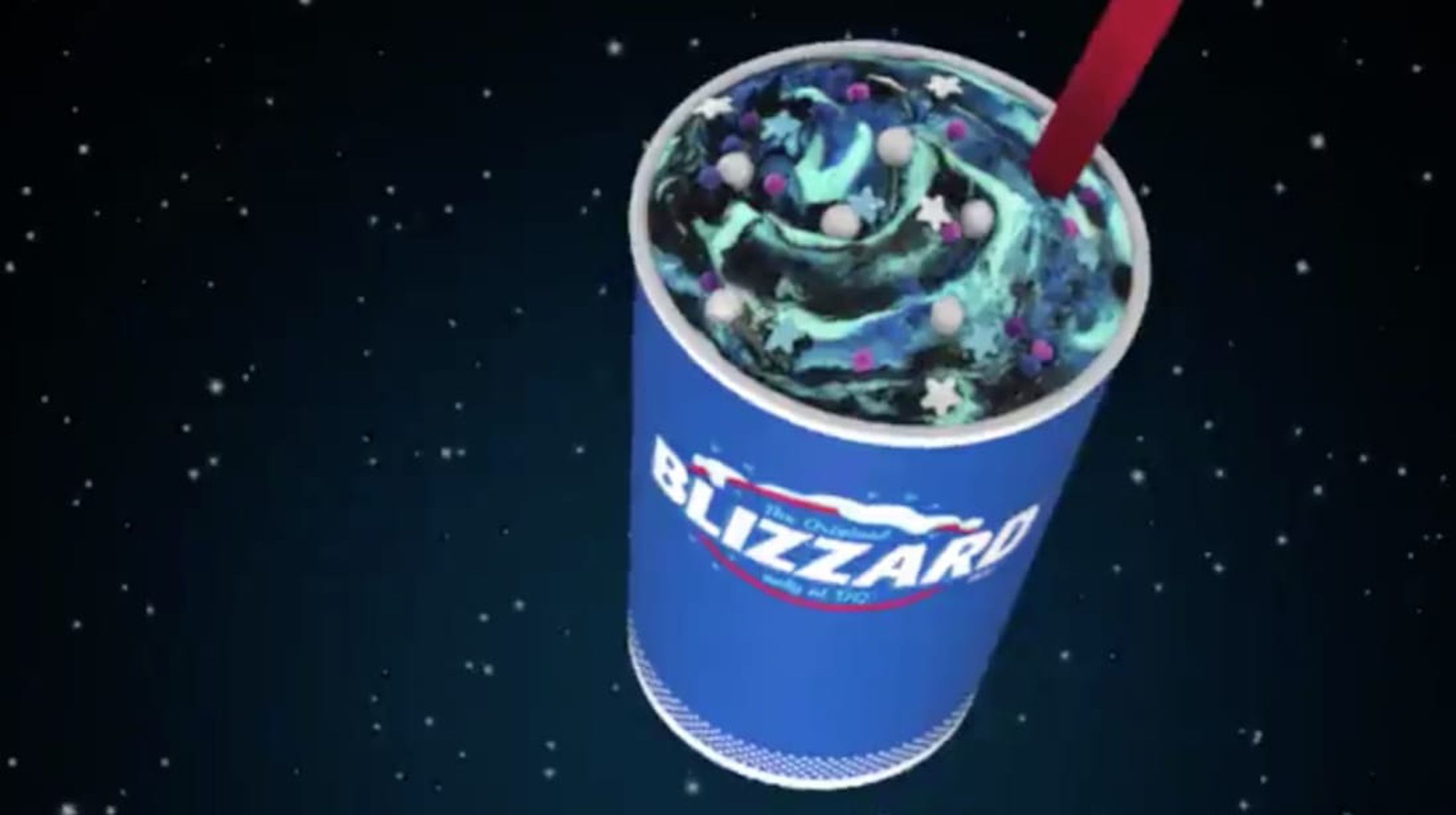 Blue cup with a green, purple, and blue drink with a red straw. 