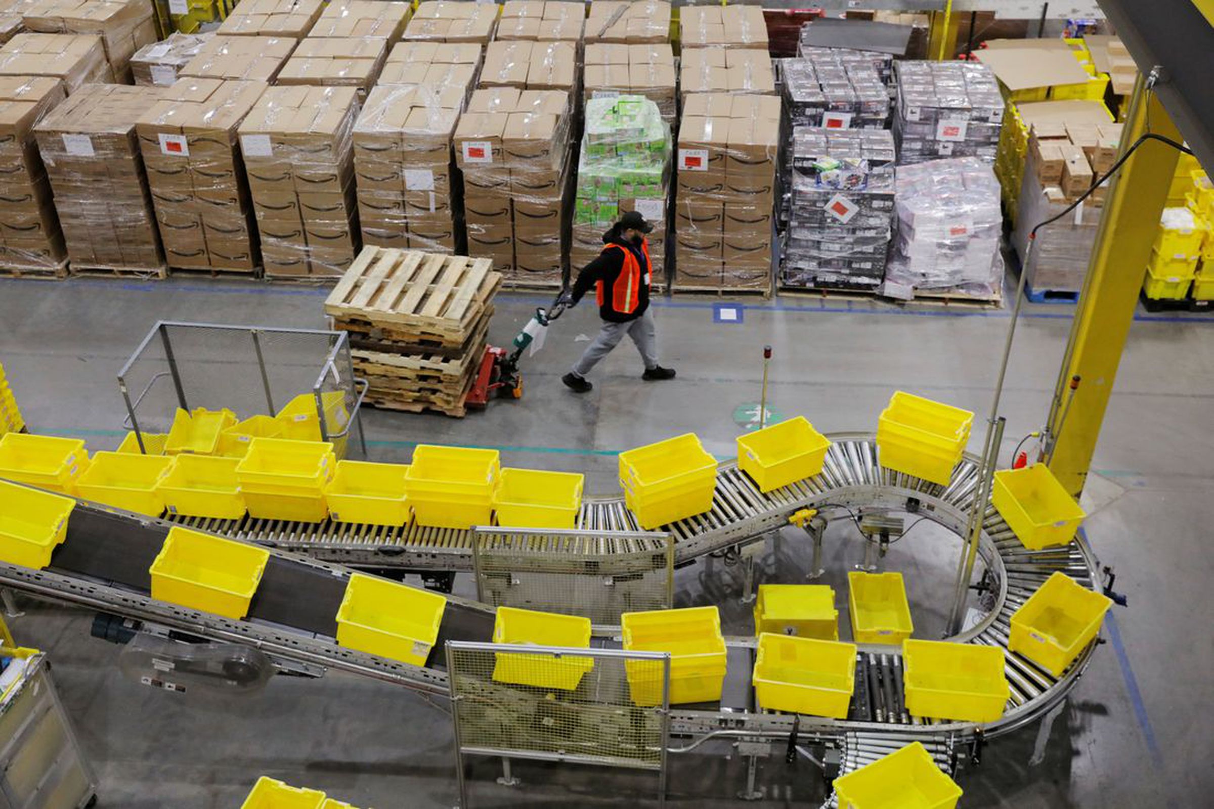 Amazon workers perform their jobs inside of an Amazon fulfillment center.