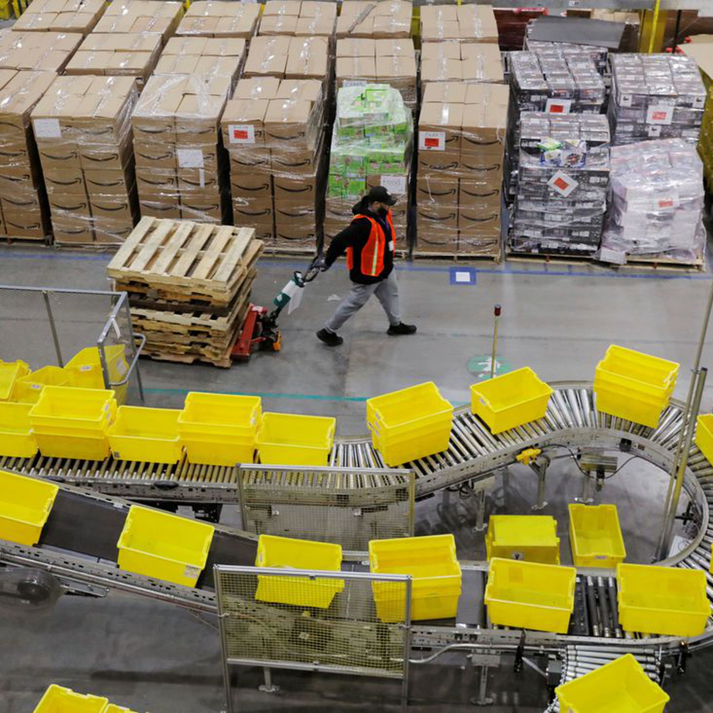Amazon workers perform their jobs inside of an Amazon fulfillment center.