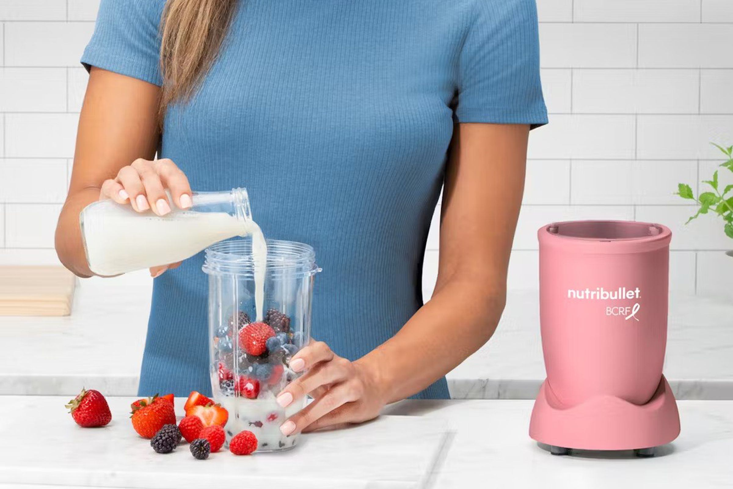 A woman preparing fruits to add to the Nutribullet Pro.
