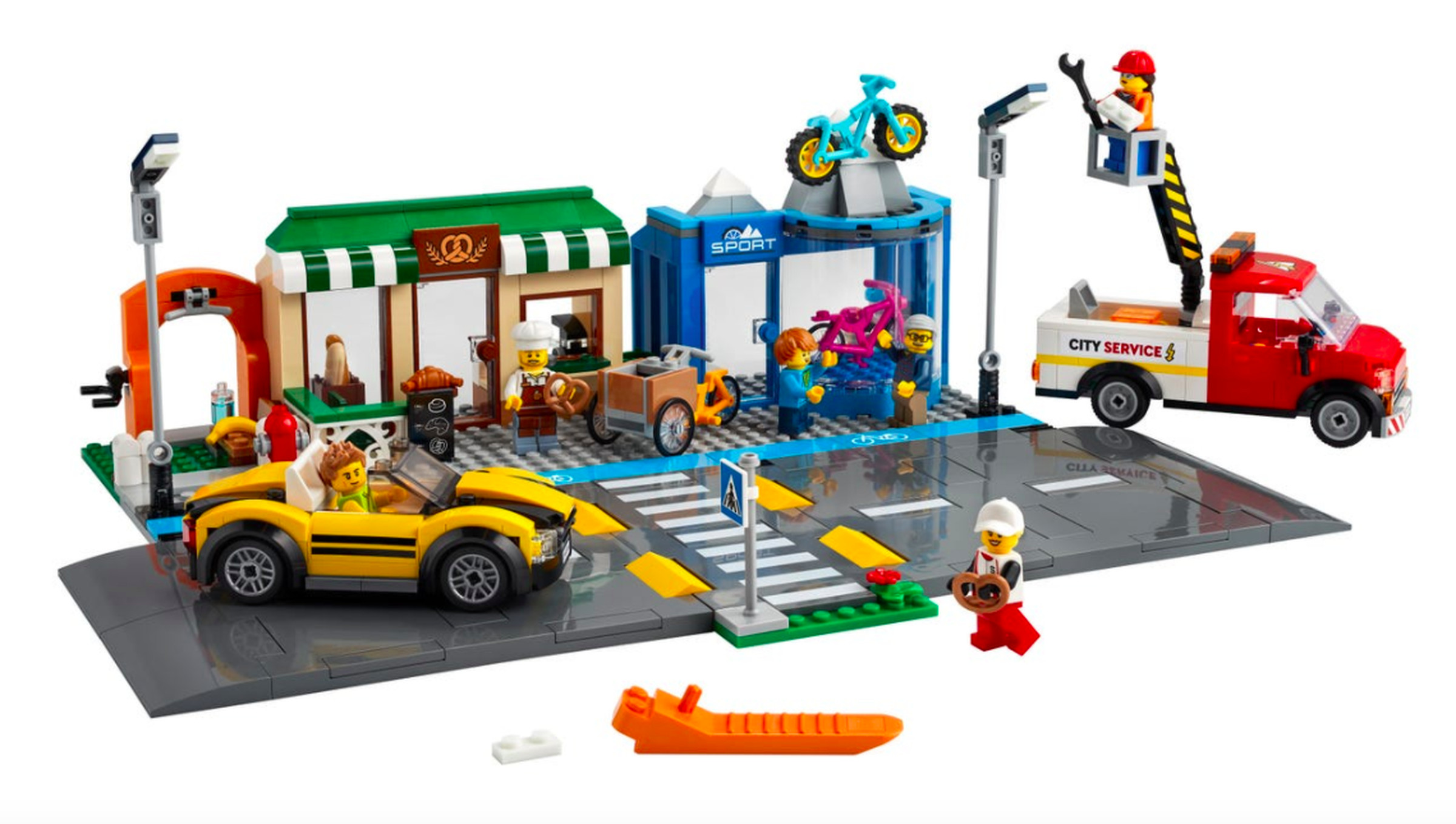 The new official Shopping Street lego set has a tiny blue bike lane next to a large road and small shops.