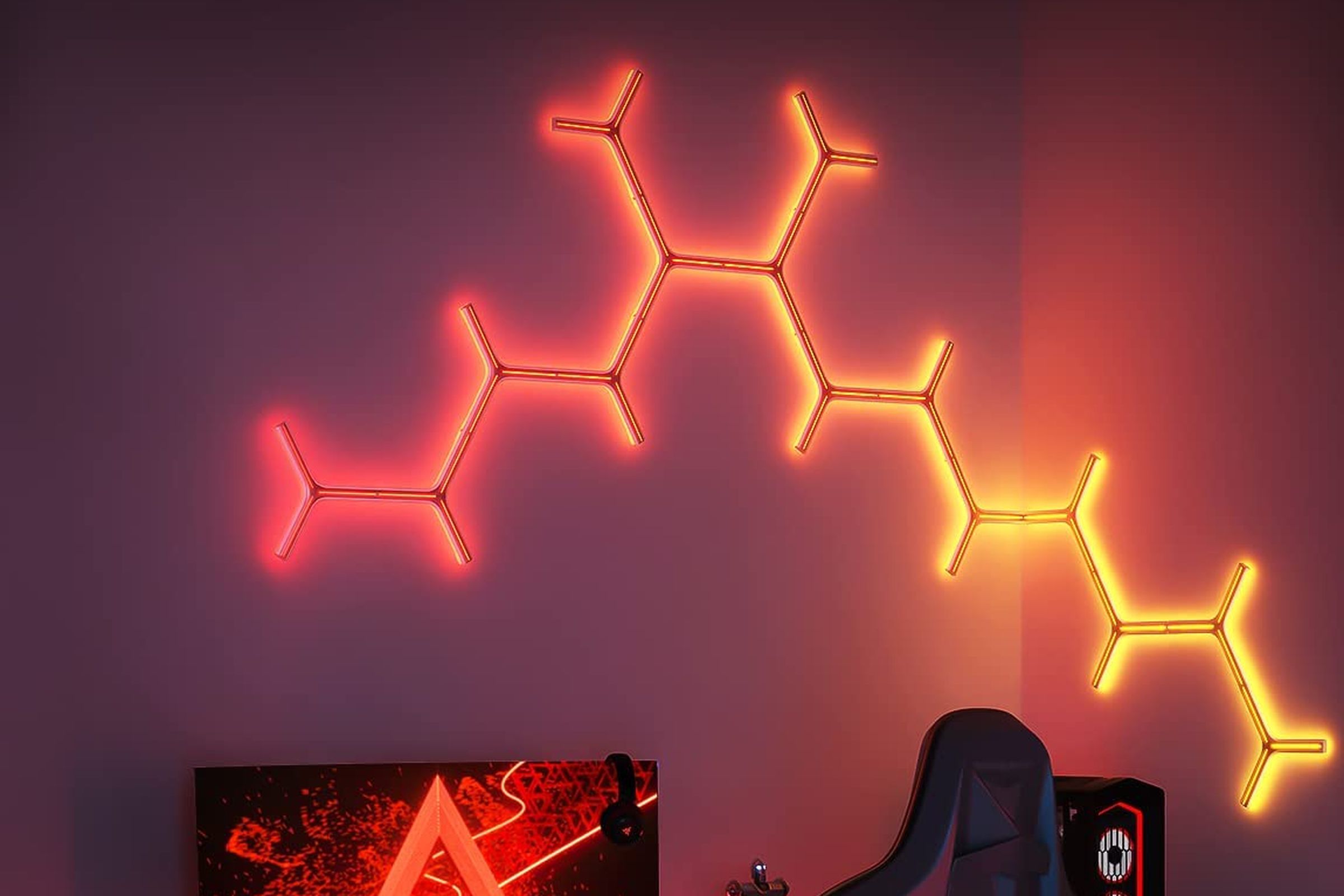 A selection of Govee’s Glide Y Lights illuminating the wall above a computer with a red glow.