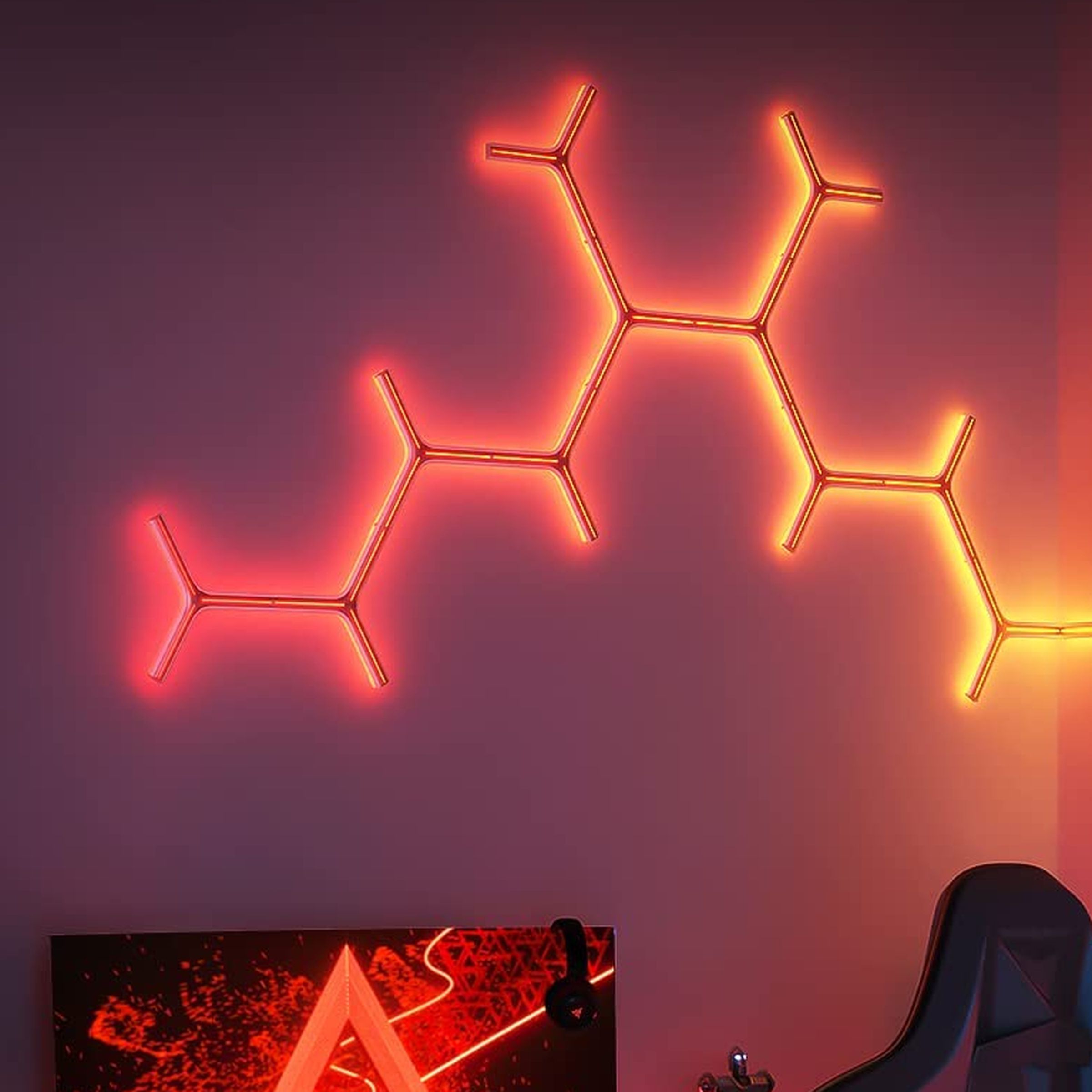 A selection of Govee’s Glide Y Lights illuminating the wall above a computer with a red glow.