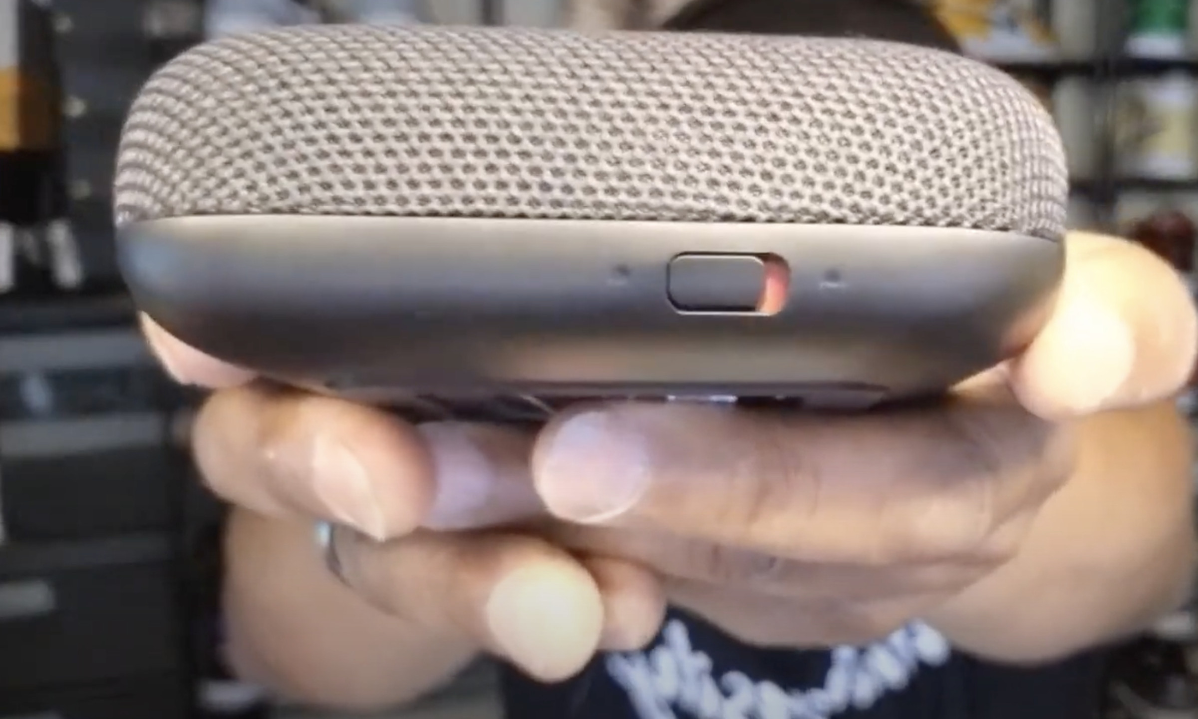 A screenshot from the video showing the microphone switch on the front of the Onn Pro.