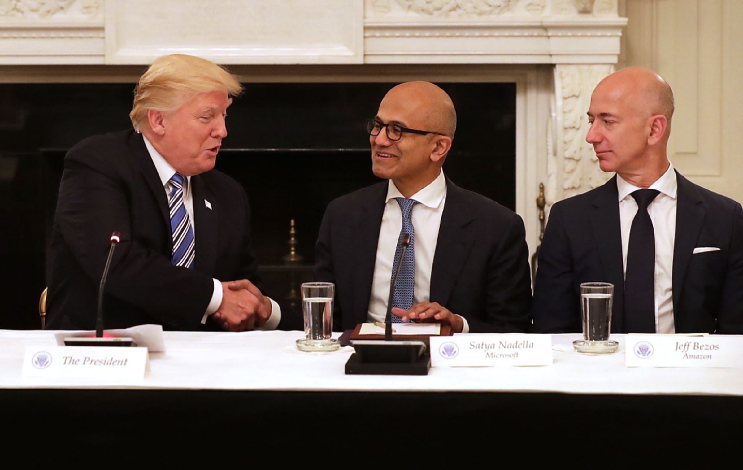 President Trump shakes hands with Microsoft CEO Satya Nadella in 2017 as Amazon CEO Jeff Bezos looks on. 