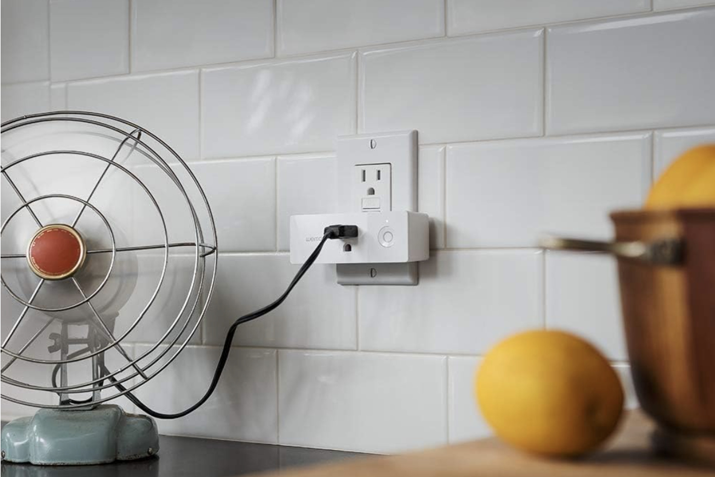 Fan plugged into smart plug on kitchen counter.
