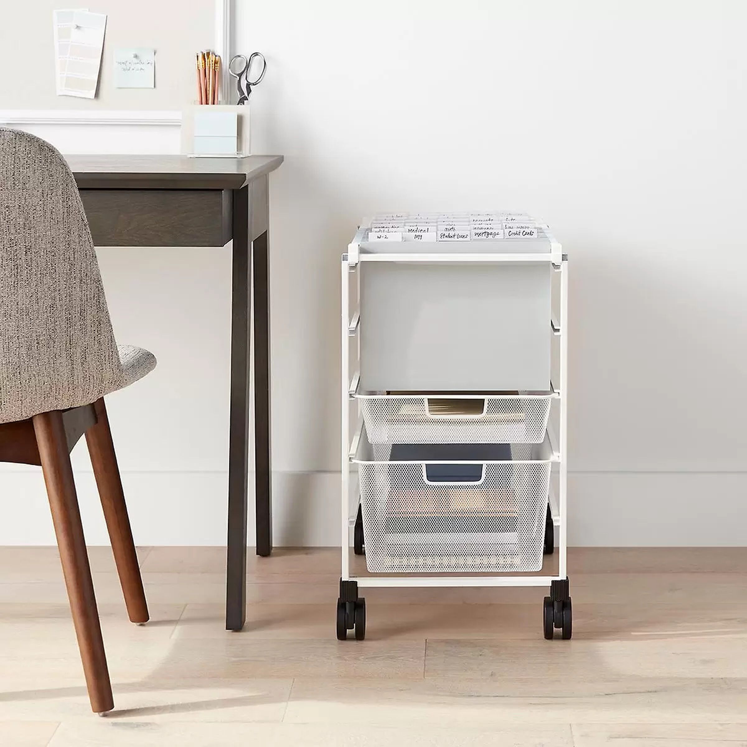 Small white wheeled cart next to desk.