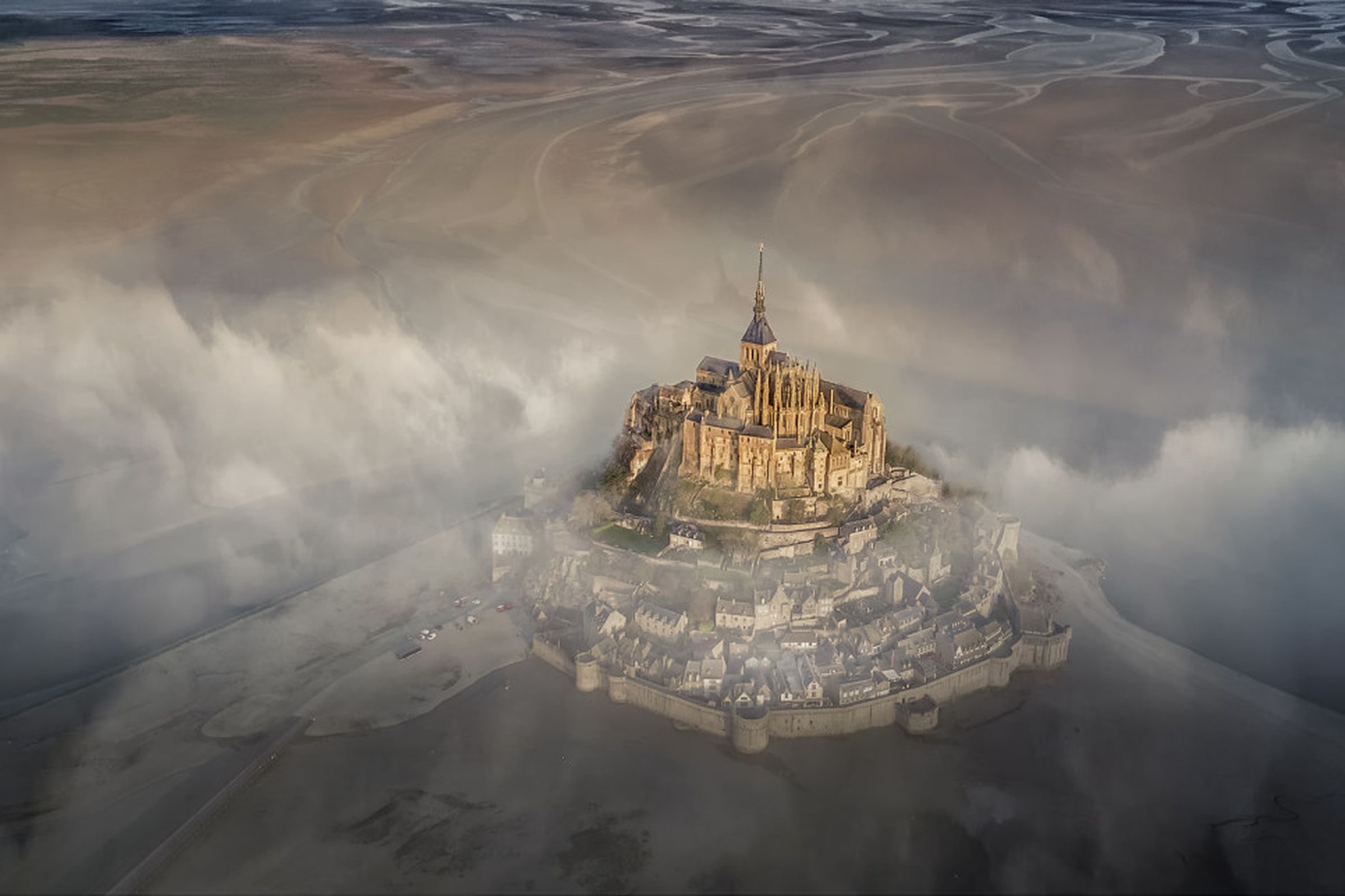 “The famous monastery of Mont Saint Michel during a foggy morning.”