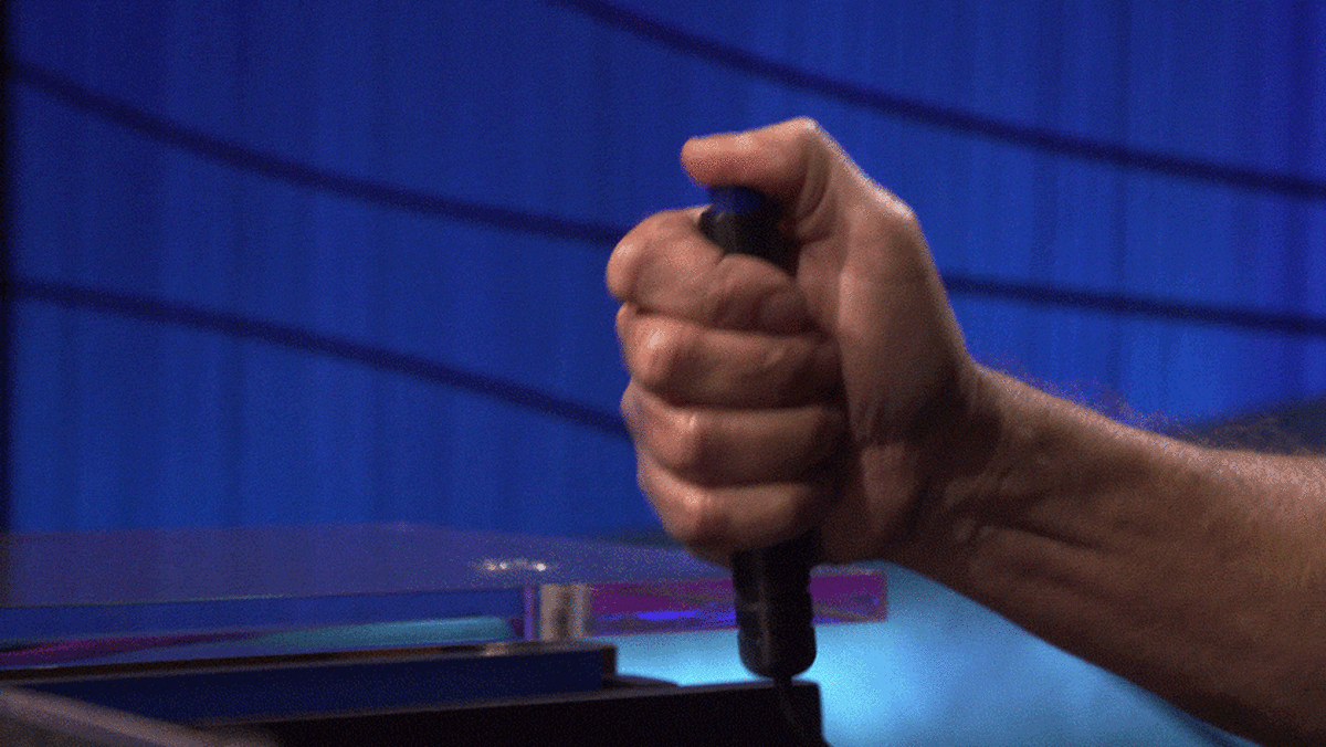 A looping image of a hand pressing down on the Jeopardy buzzer button.