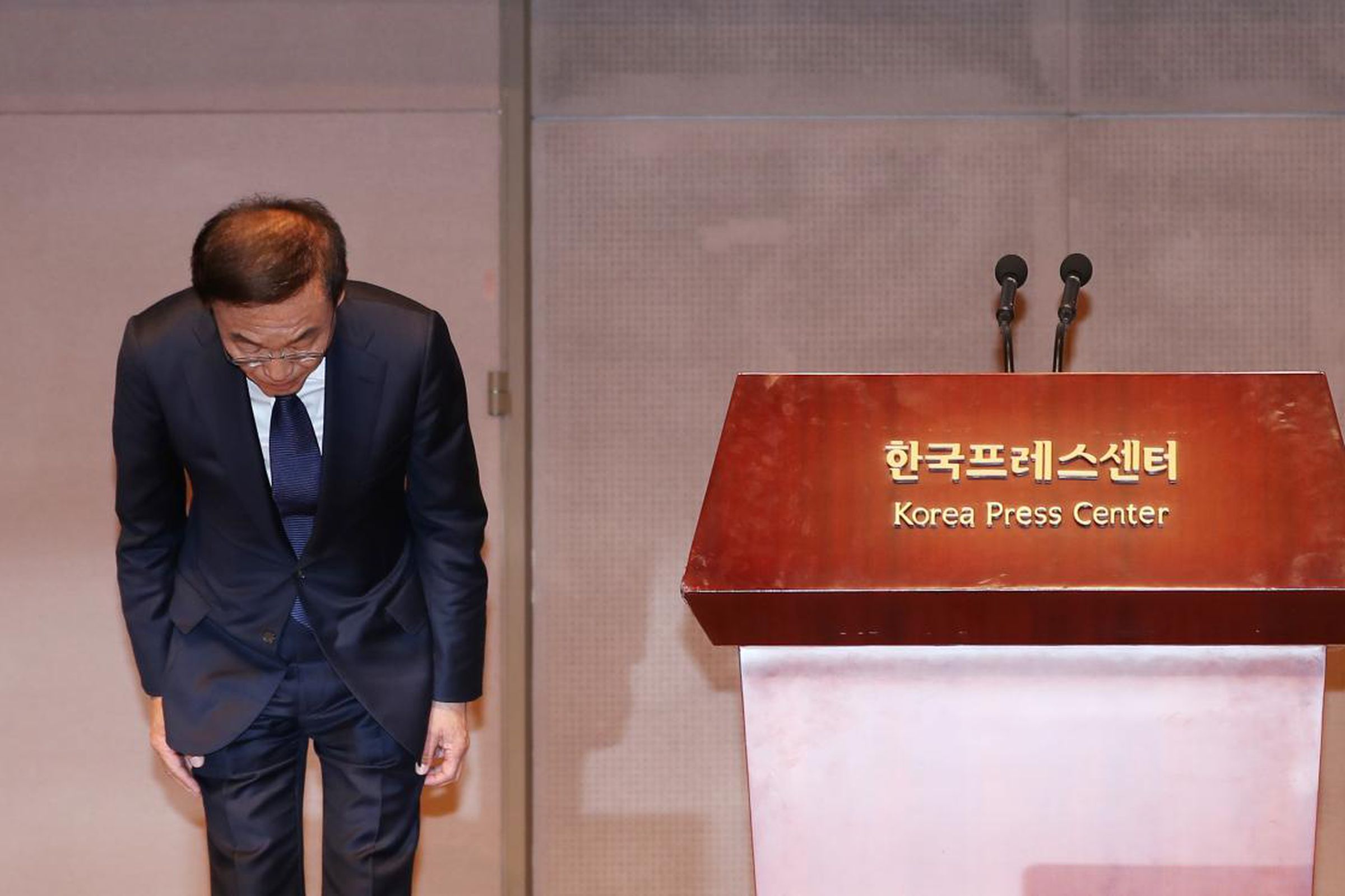 Samsung Electronics President and CEO Kim Ki-nam bows in apology during the Seoul press conference announcing the compensation. 