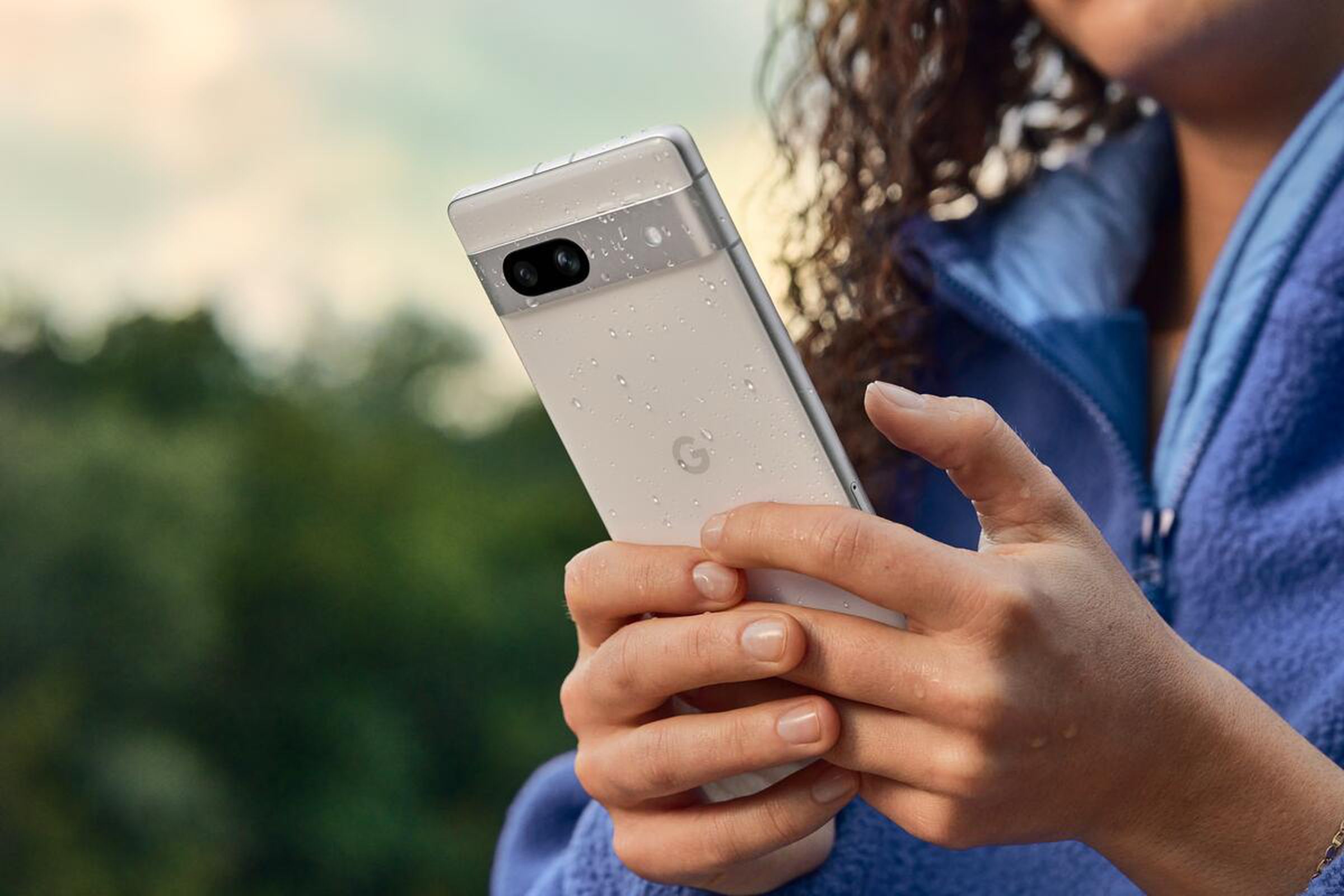 A marketing image of a Google Pixel 7A with water droplets on the back.