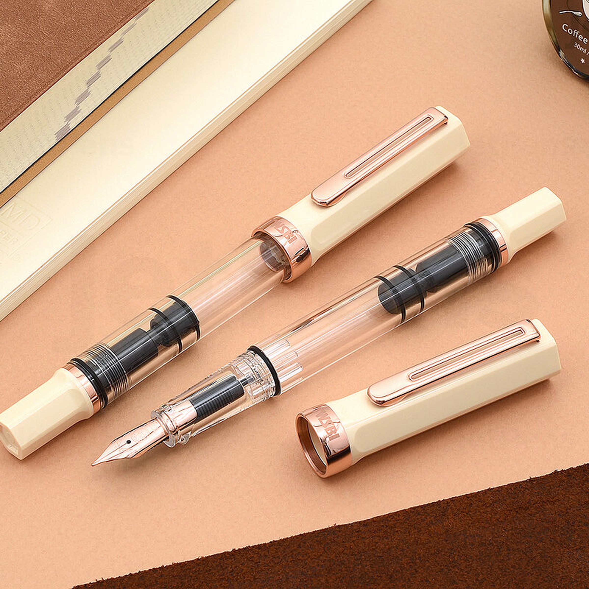 Rose-gold fountain pen in three pieces on table top.