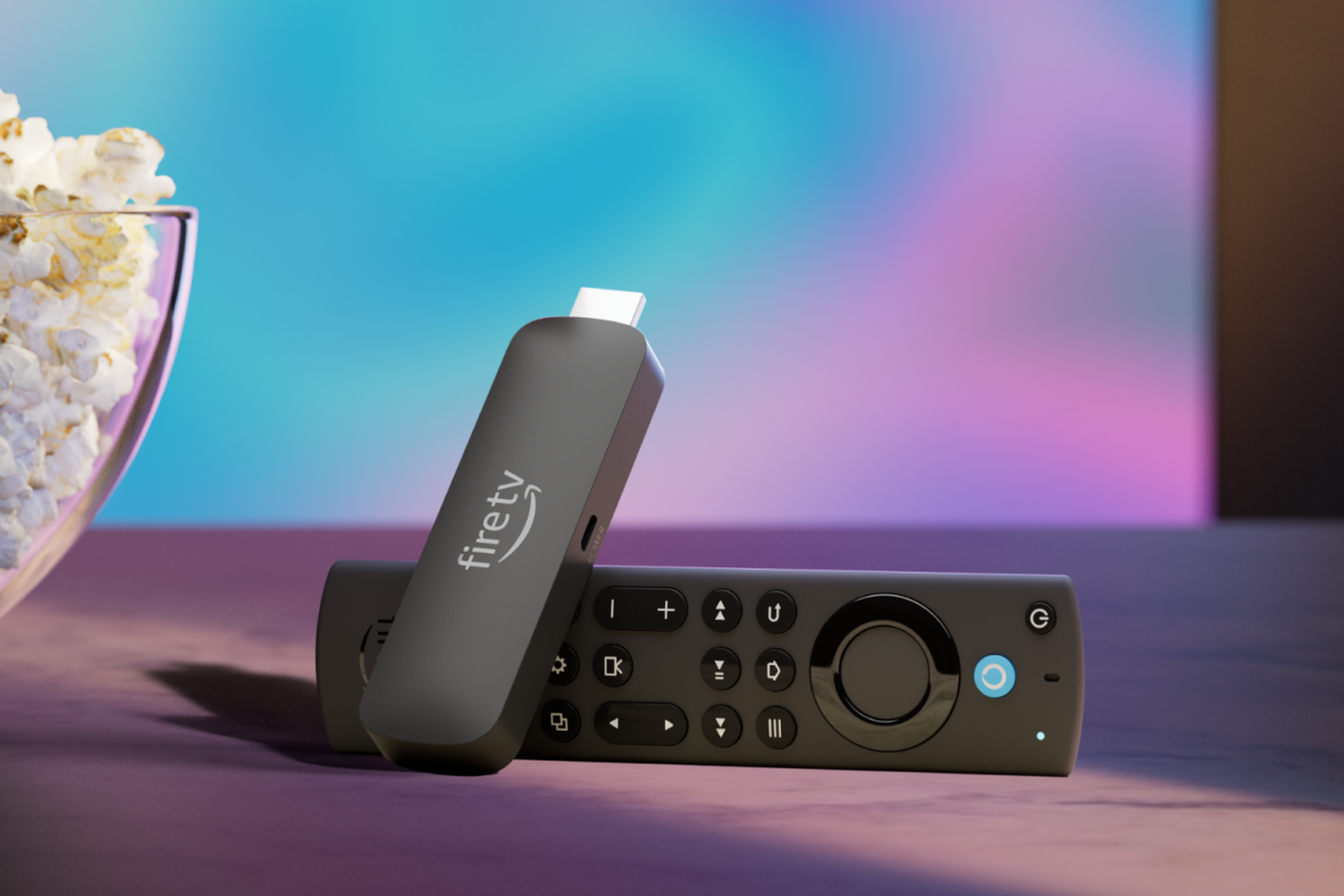 An Amazon Fire TV Stick 4K Max streaming stick with its remote sitting beside a bowl of popcorn in front of a TV.