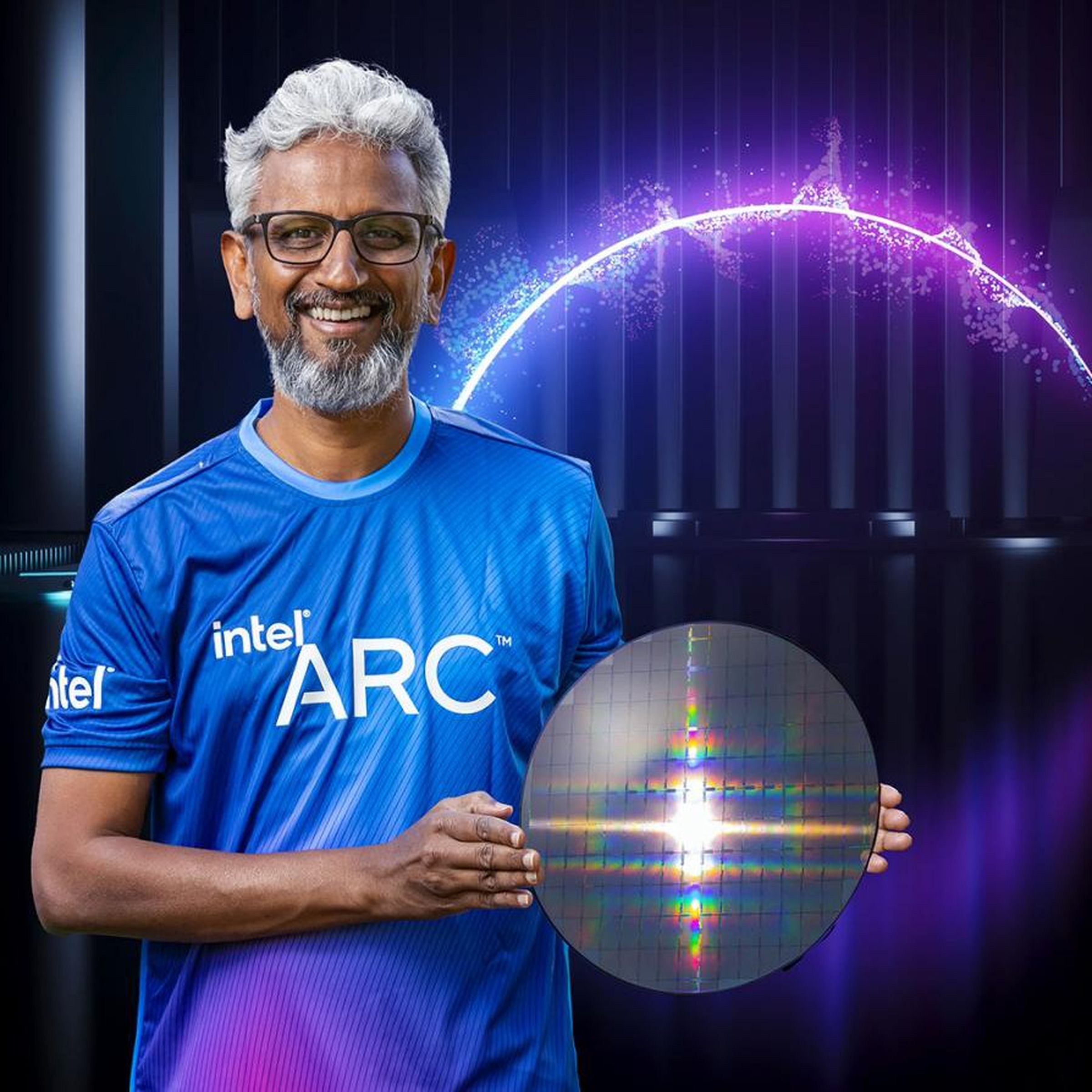 Raja Koduri, wearing a jersey celebrating the Intel Arc GPUs and holding a silicon wafer.