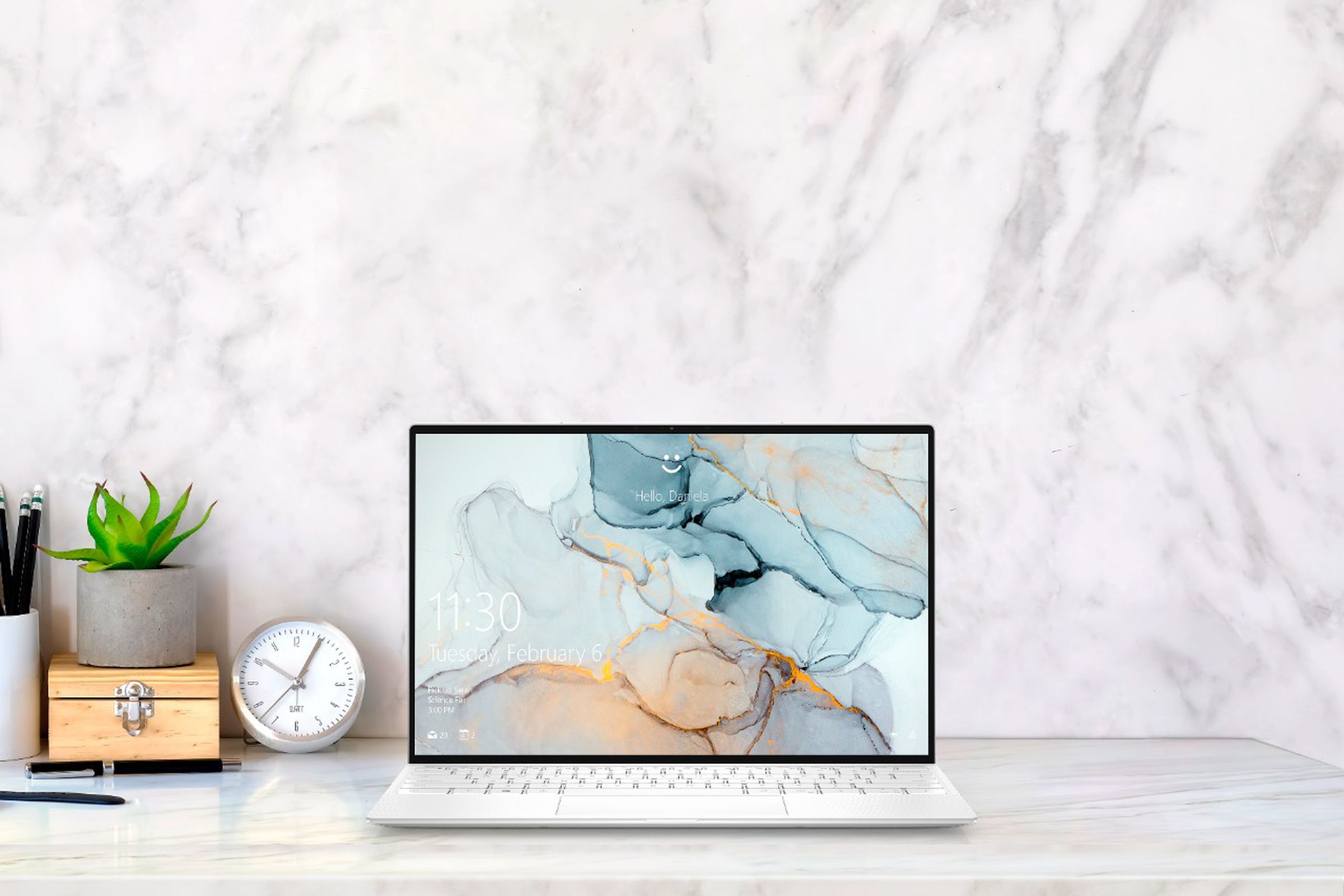 The Dell XPS 13 sits on a desk with a marble background.