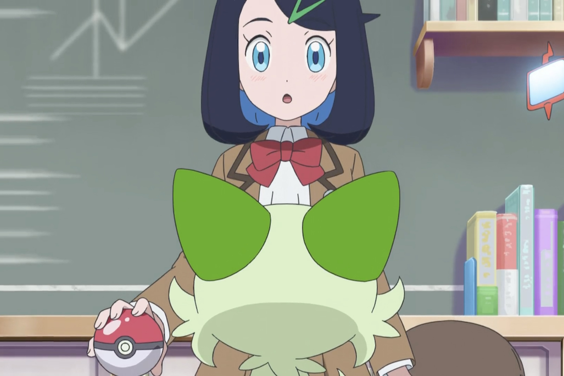 A girl in a brown Japanese school uniform looking down at a green cat that’s facing her.