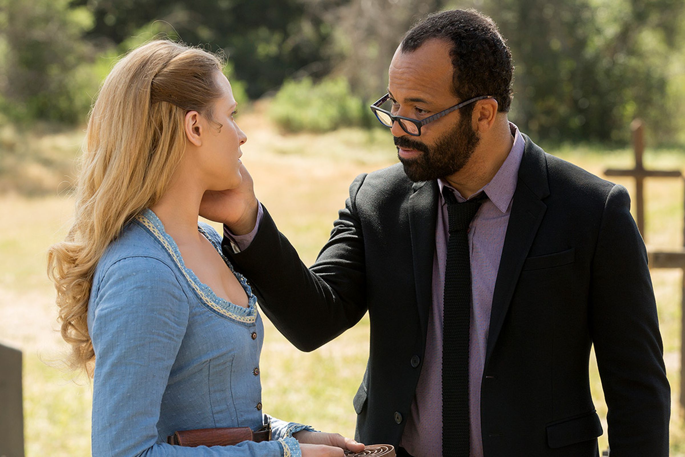 Jeffrey Wright, dressed in contemporary clothes, gently touches the face of Evan Rachel Wood, who is dressed as a woman from the 1880s.