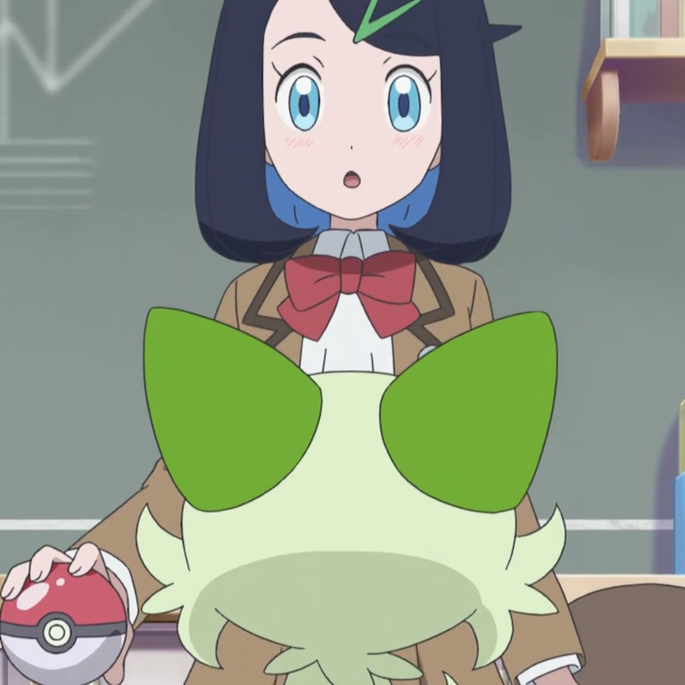A girl in a brown Japanese school uniform looking down at a green cat that’s facing her.
