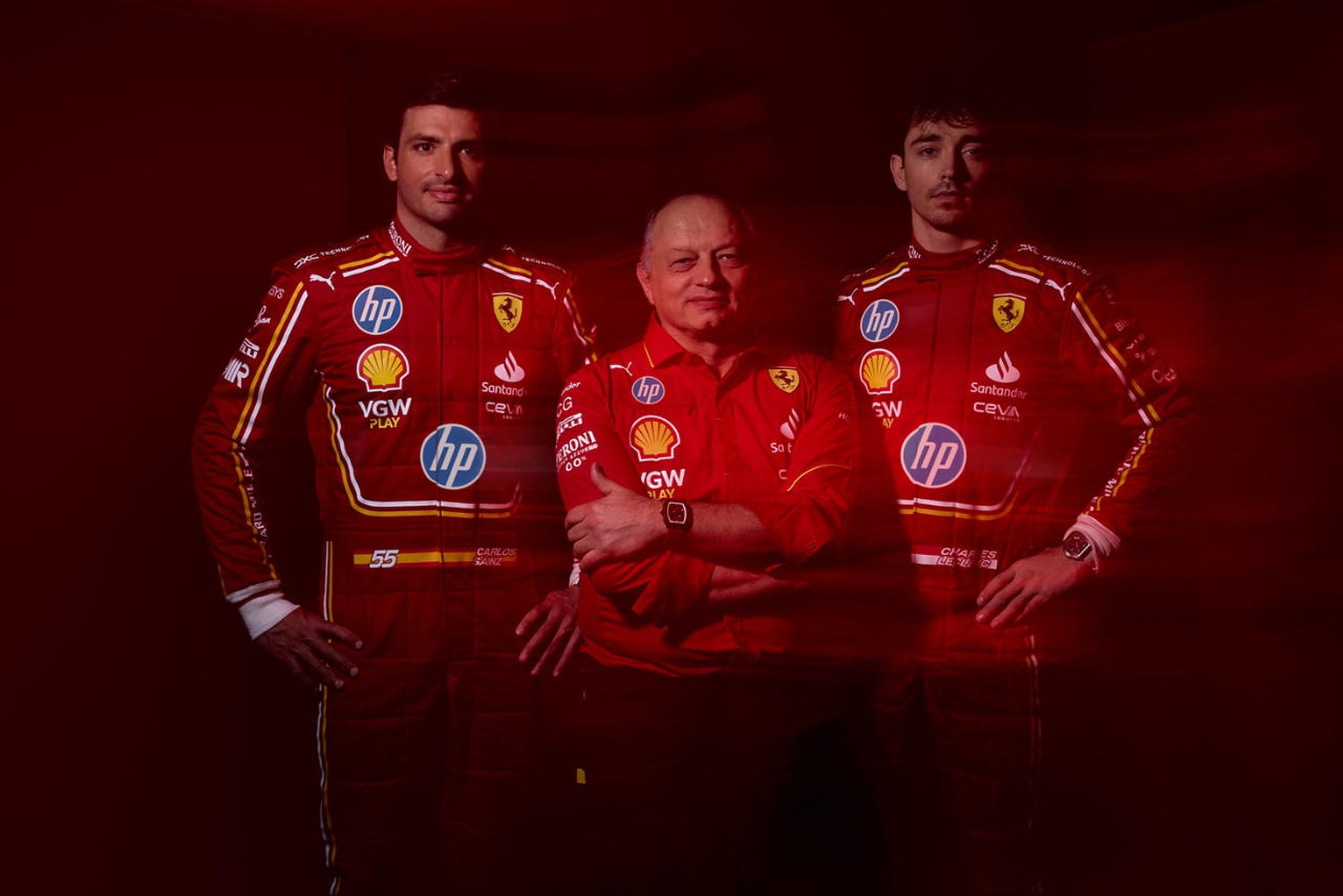 Three people in red racing uniforms pose for a photo.