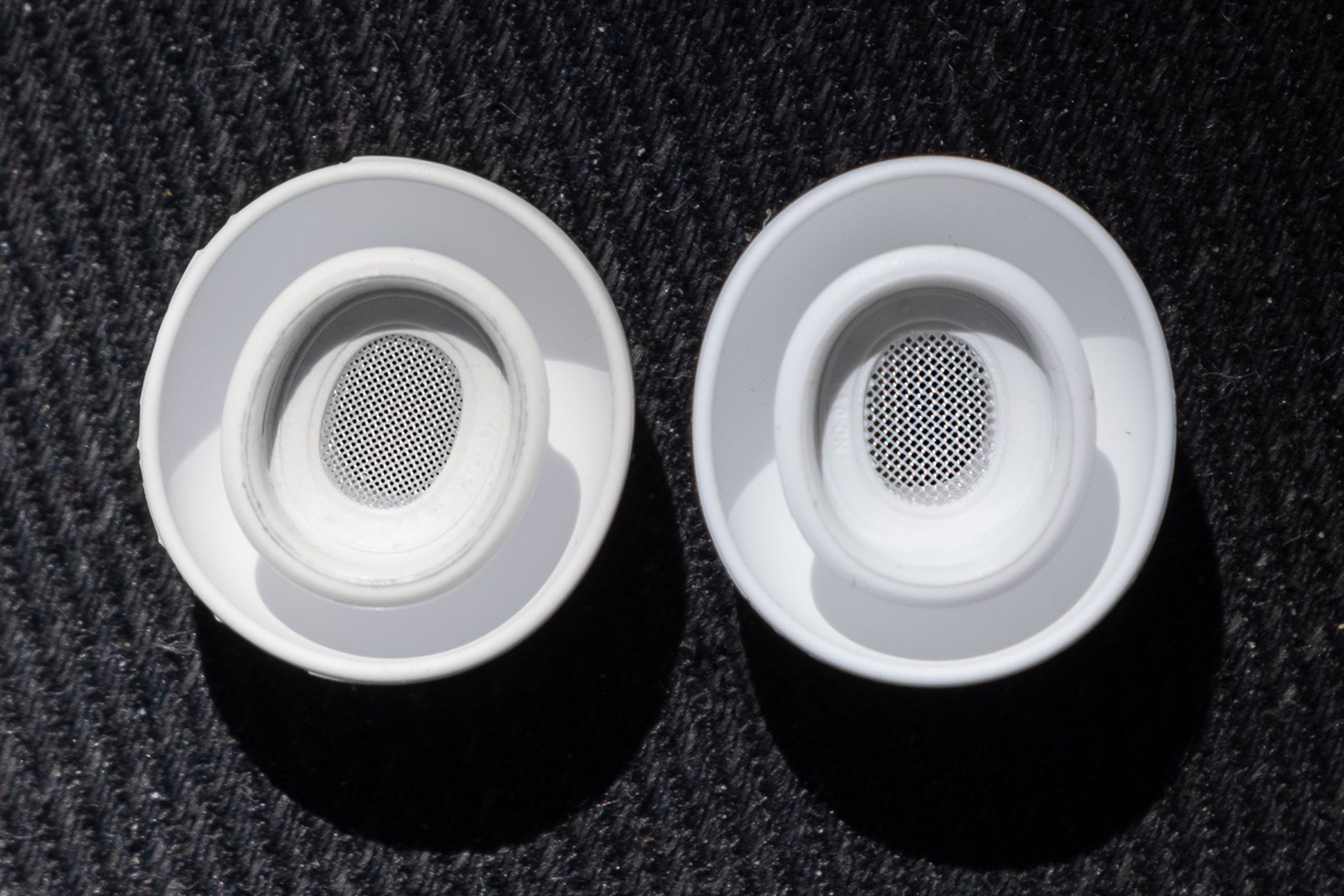 A close-up image comparing the ear tips of Apple’s original AirPods Pro and the second-generation model released in 2022.